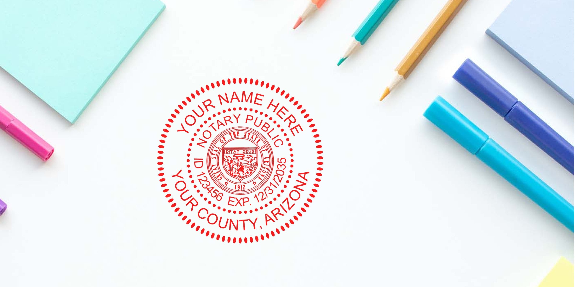Red circular notary public seal mockup in red ink saying "Your Name Here, Your County, Arizona" on white desk with colorful pens, pencils and sticky notes.