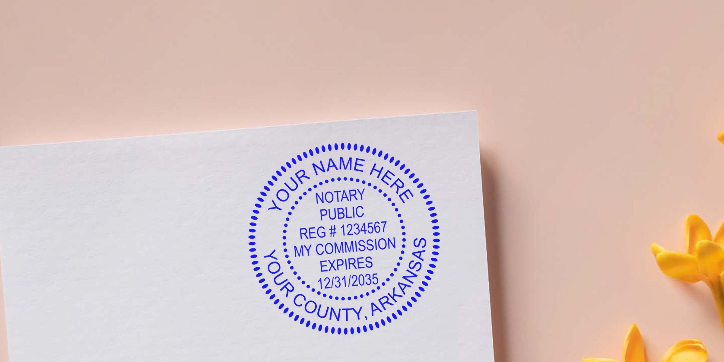Blue circular notary public stamp mockup on white paper with placeholder text "Your Name Here, Your County, Arkansas", registration number and commission expiry details, soft pink background and yellow flowers.
