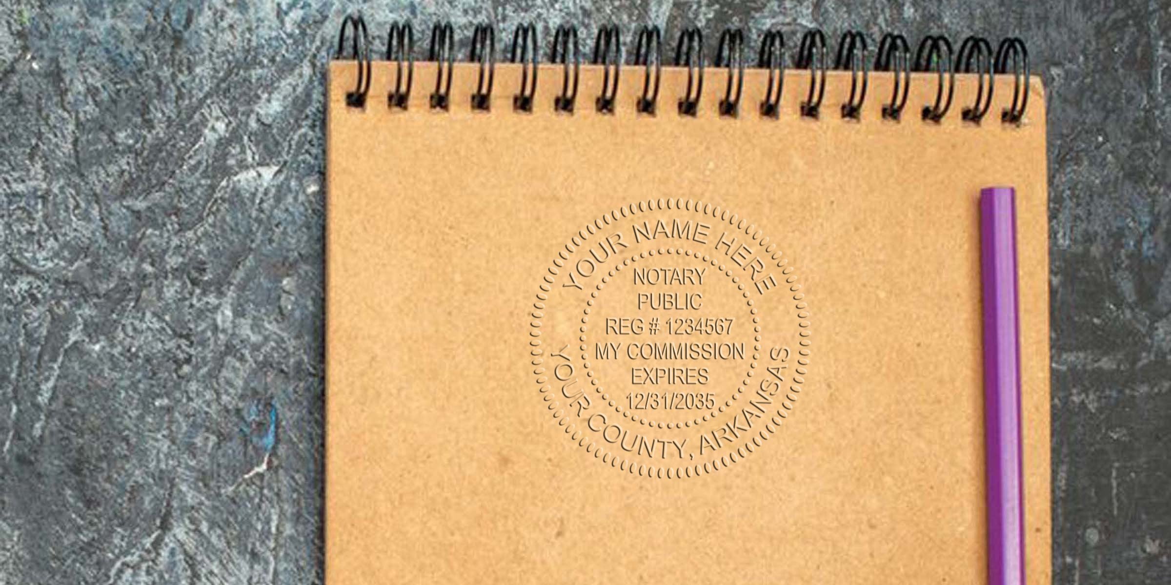 Spiral kraft notebook with embossed notary public seal centered on page, purple pencil along right edge on dark textured background — kraft journal, notary seal embossing, office stationery photograph.