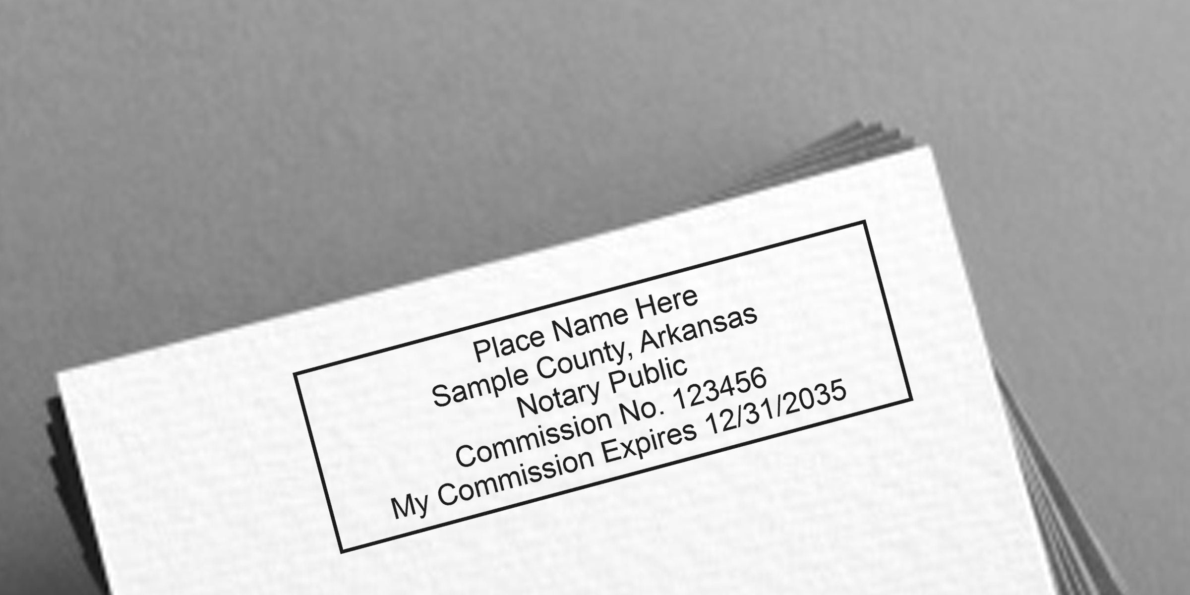 Stack of white papers with a rectangular notary stamp reading "Place Name Here, Sample County, Arkansas, Notary Public, Commission No. 123456, My Commission Expires 12/31/2035"