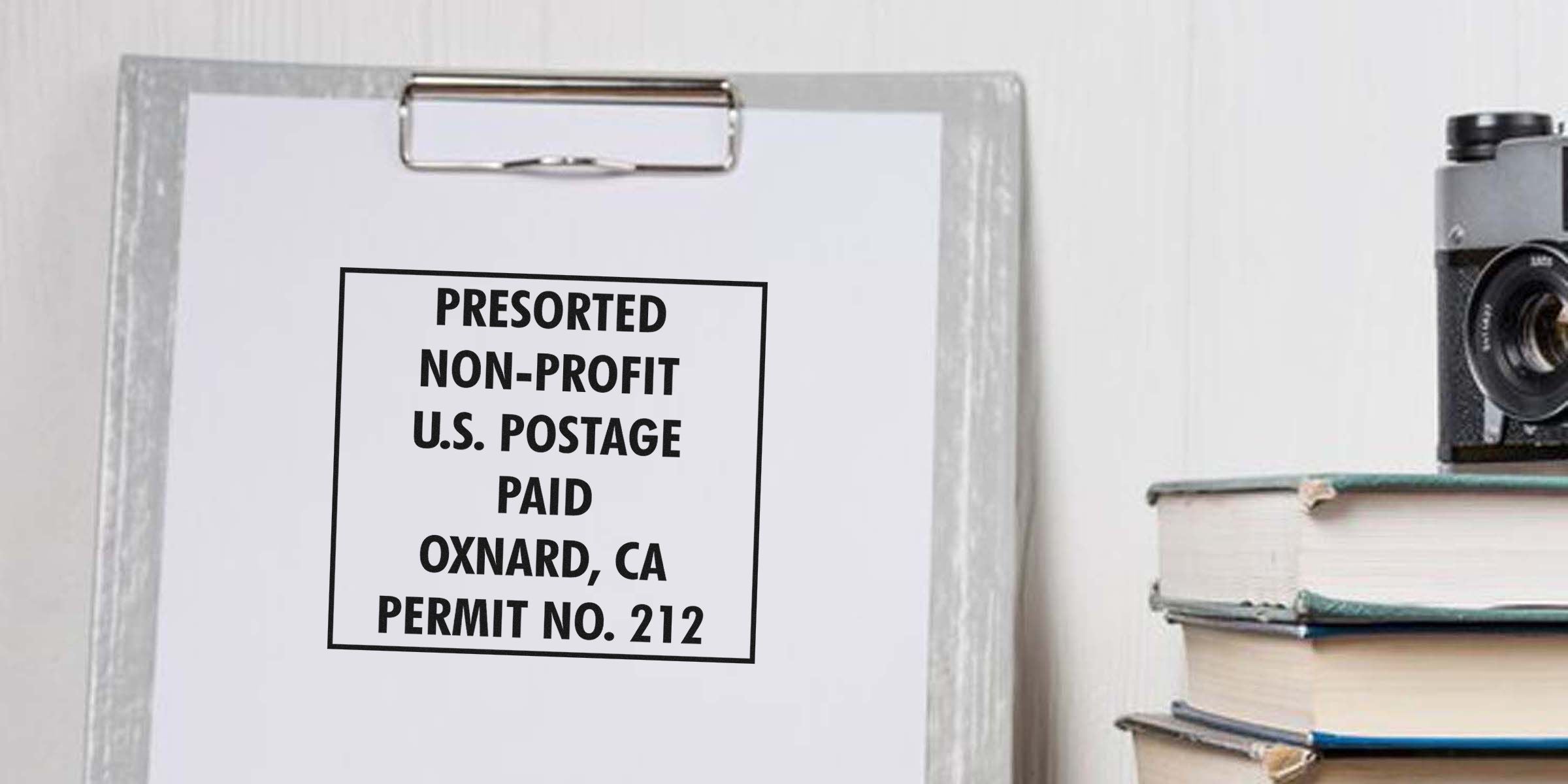 Label reading PRESORTED NON-PROFIT U.S. POSTAGE PAID OXNARD, CA PERMIT NO. 212 on a clipboard.