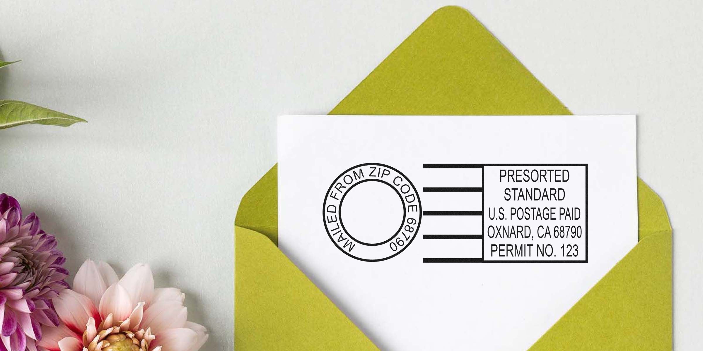 White envelope with a black postage imprint on a lime-green envelope, pink flowers visible on the left.