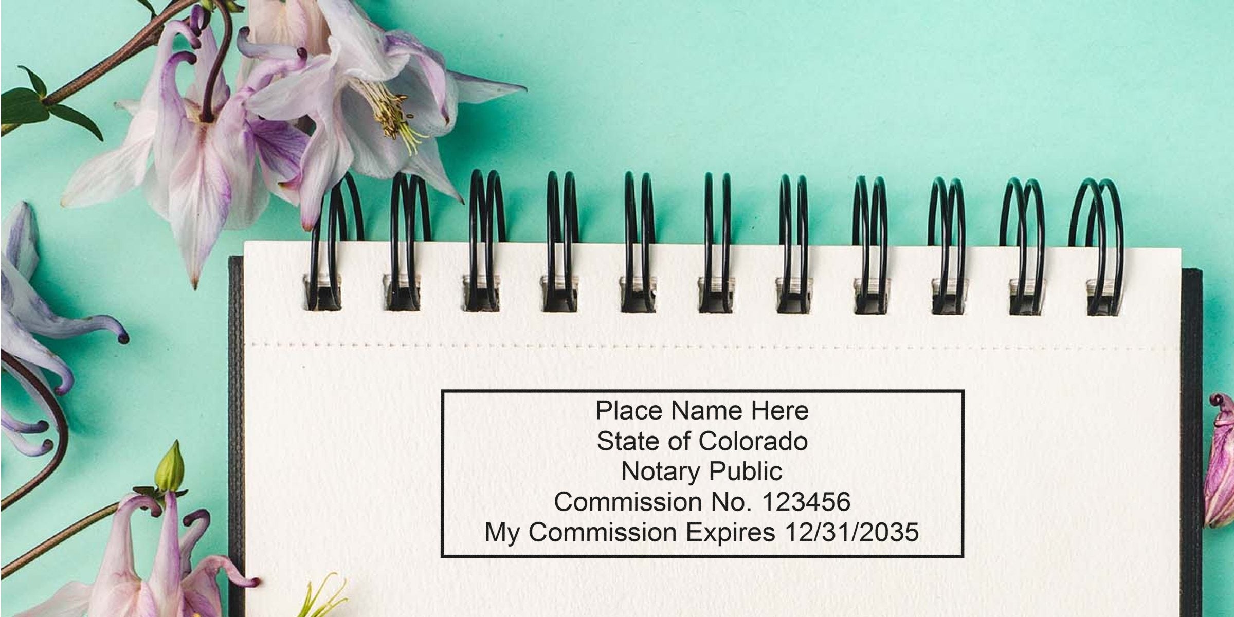 Notary stamp template on spiral notebook reading "State of Colorado Notary Public Commission No. 123456" with pastel purple flowers on teal background, stationery mockup for notary services and office supplies