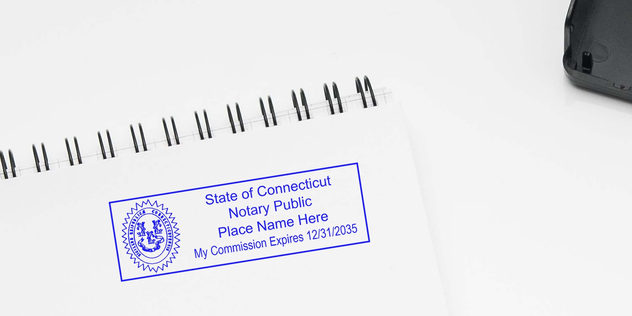 Blue State of Connecticut Notary Public stamp on white spiral-bound notebook, circular state seal at left, placeholder name and commission expiration 12/31/2035