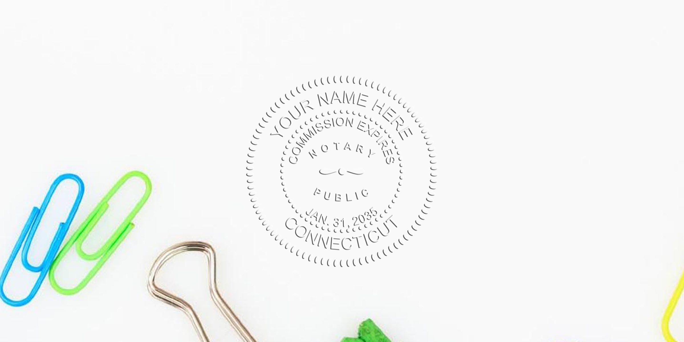 Embossed notary public seal impression reading "Connecticut" on white paper surrounded by colorful paperclips and a binder clip