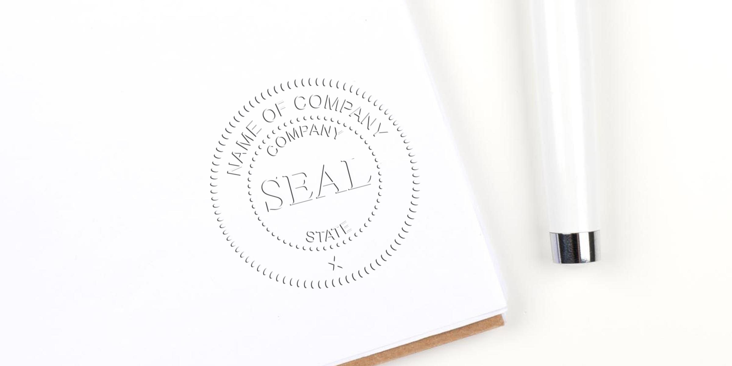 Close-up of a white notebook page with a circular embossed seal reading "SEAL" and a white pen beside it.