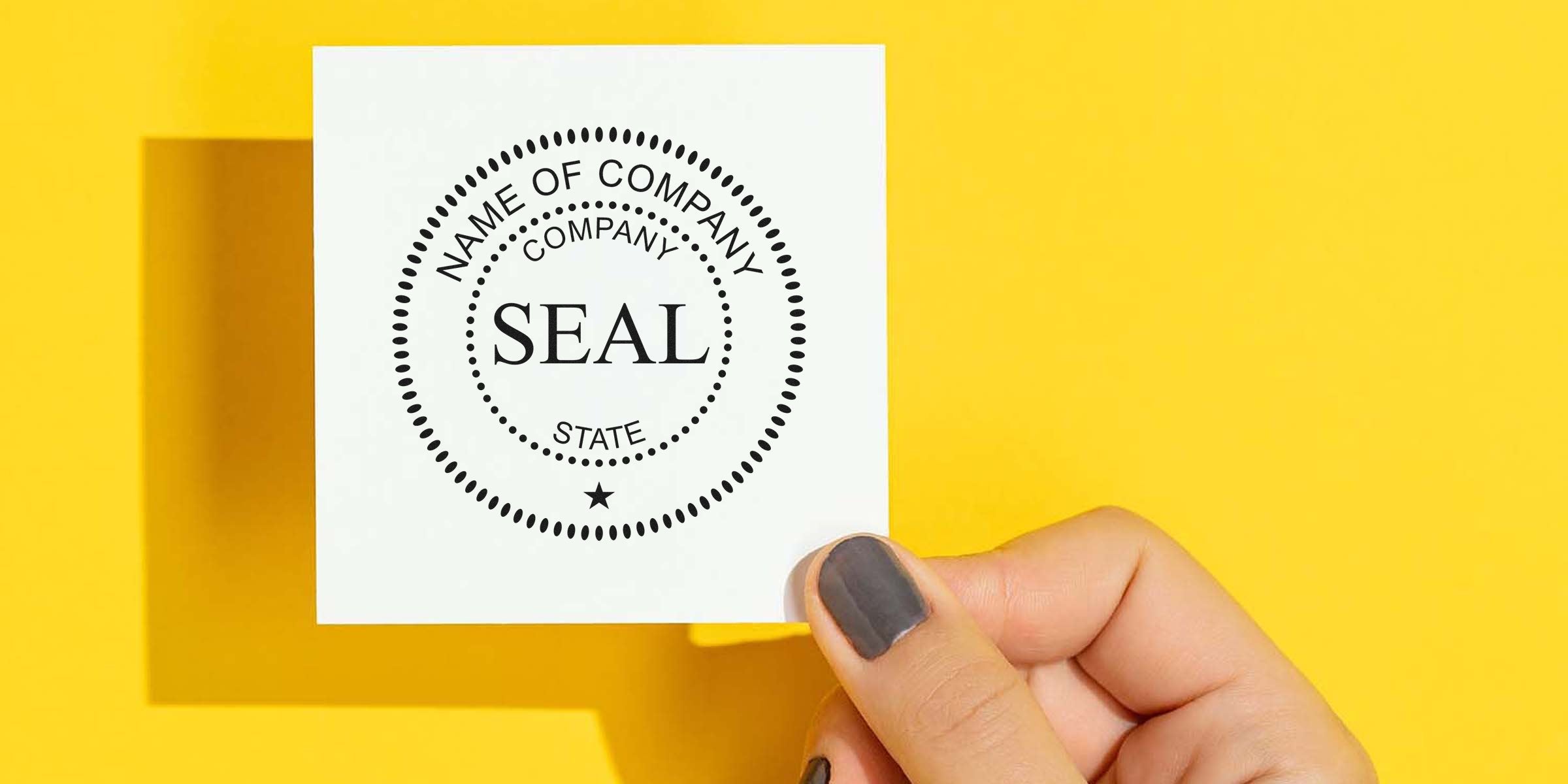 White card with a black circular “SEAL” stamp, held by a hand against a bright yellow background.