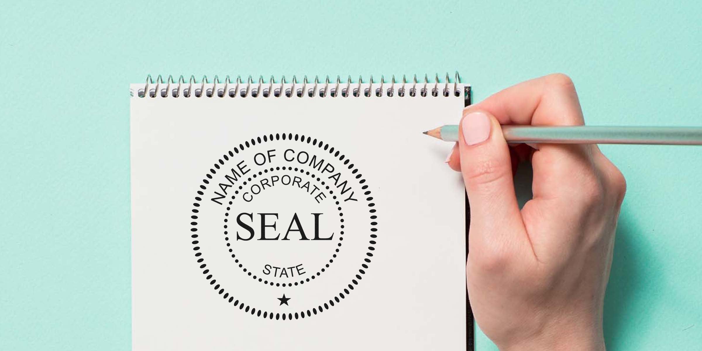 Close-up of a spiral notebook with a circular seal reading “SEAL” on the page, while a hand holds a pencil.
