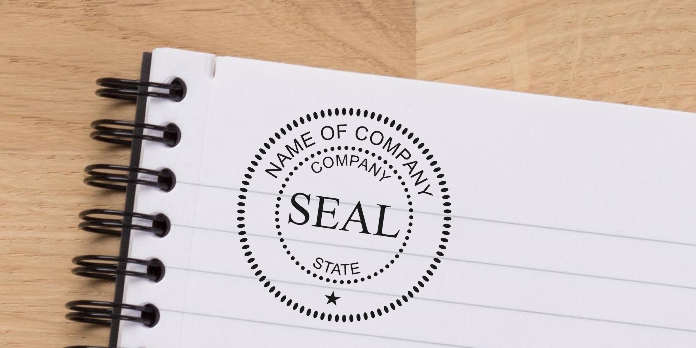 Circular seal stamp with the word SEAL in the center, surrounded by "NAME OF COMPANY," "COMPANY," and "STATE" on a white notebook page.