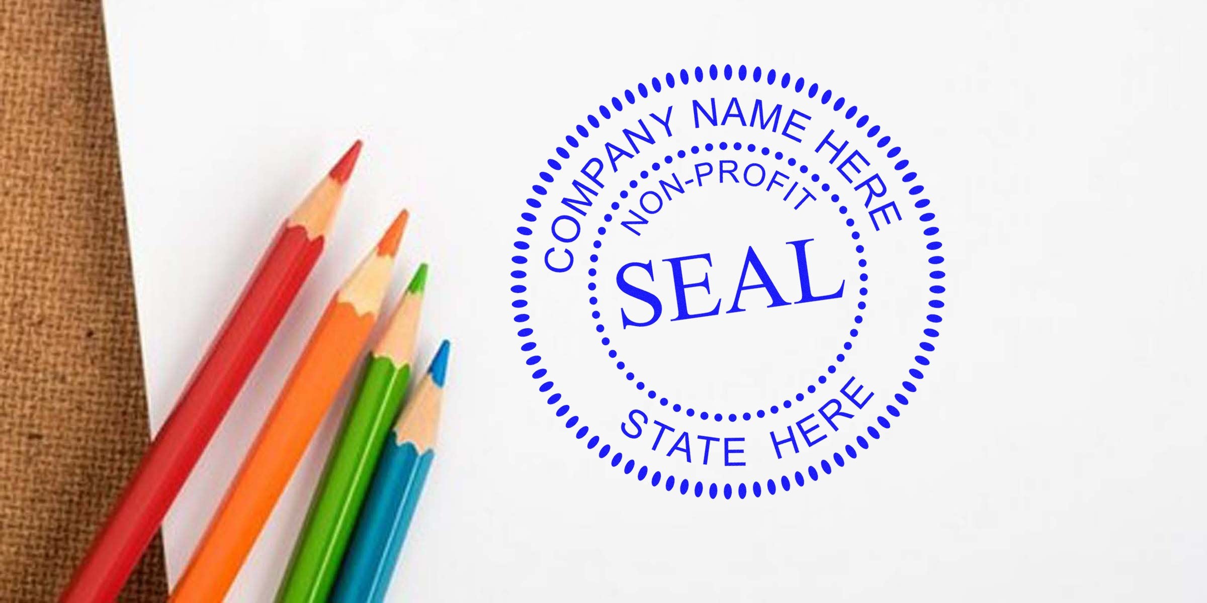 Blue circular stamp with the word “SEAL” in the center, surrounded by “COMPANY NAME HERE” and “STATE HERE,” beside a bunch of colorful pencils.