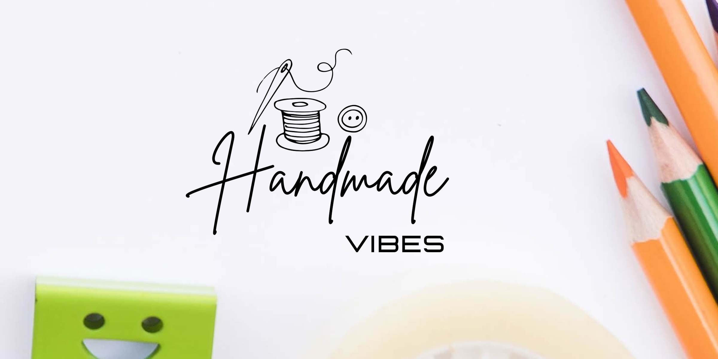Handmade Vibes logo featuring a needle, thread, spool and button with craft supplies flat lay: colored pencils, green smiling clip and masking tape on a white background.