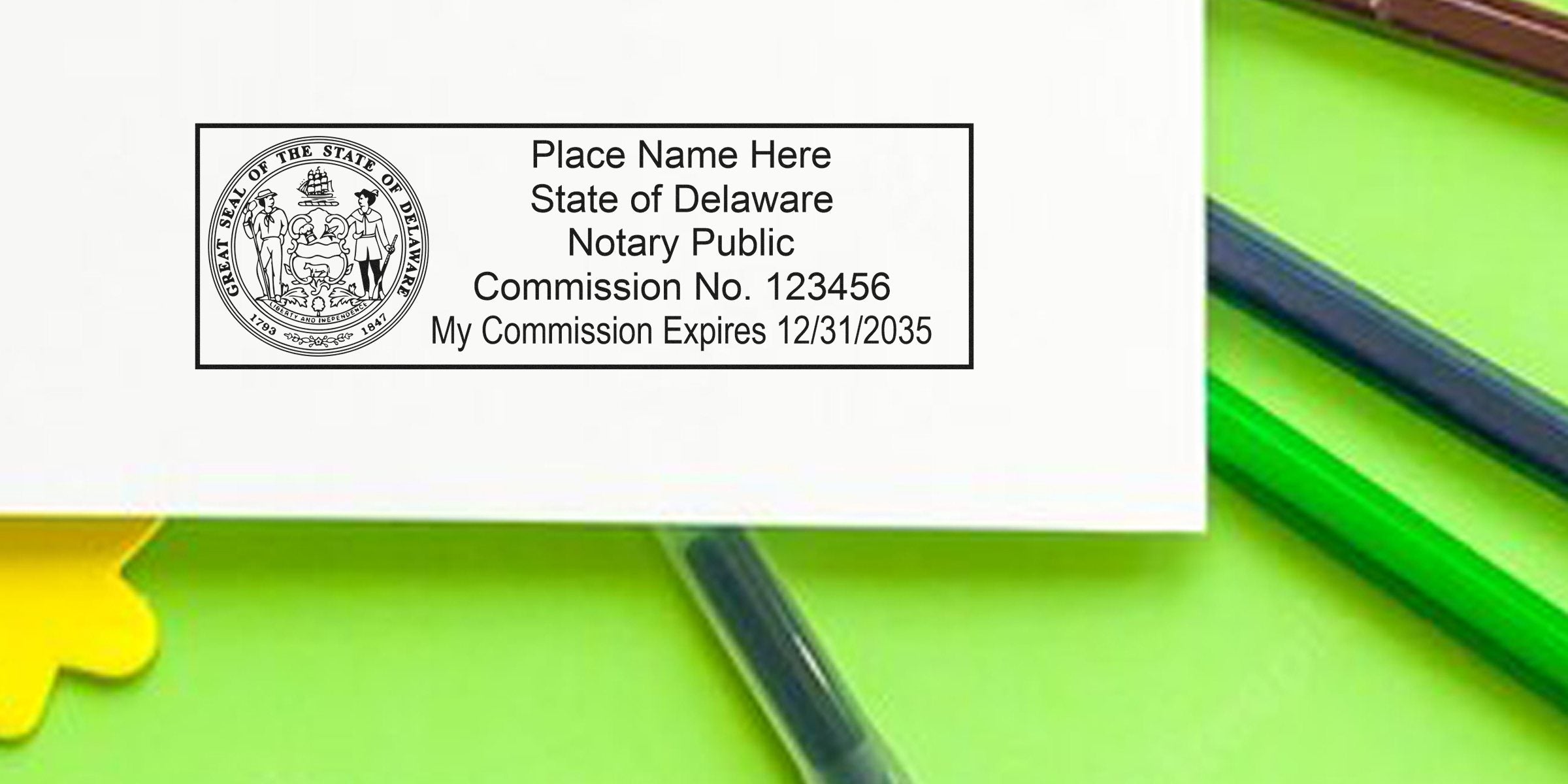 Delaware notary public stamp mockup on white paper showing state seal, placeholder name, commission no. 123456 and expiration 12/31/2035, photographed over a bright green background with colored pens.