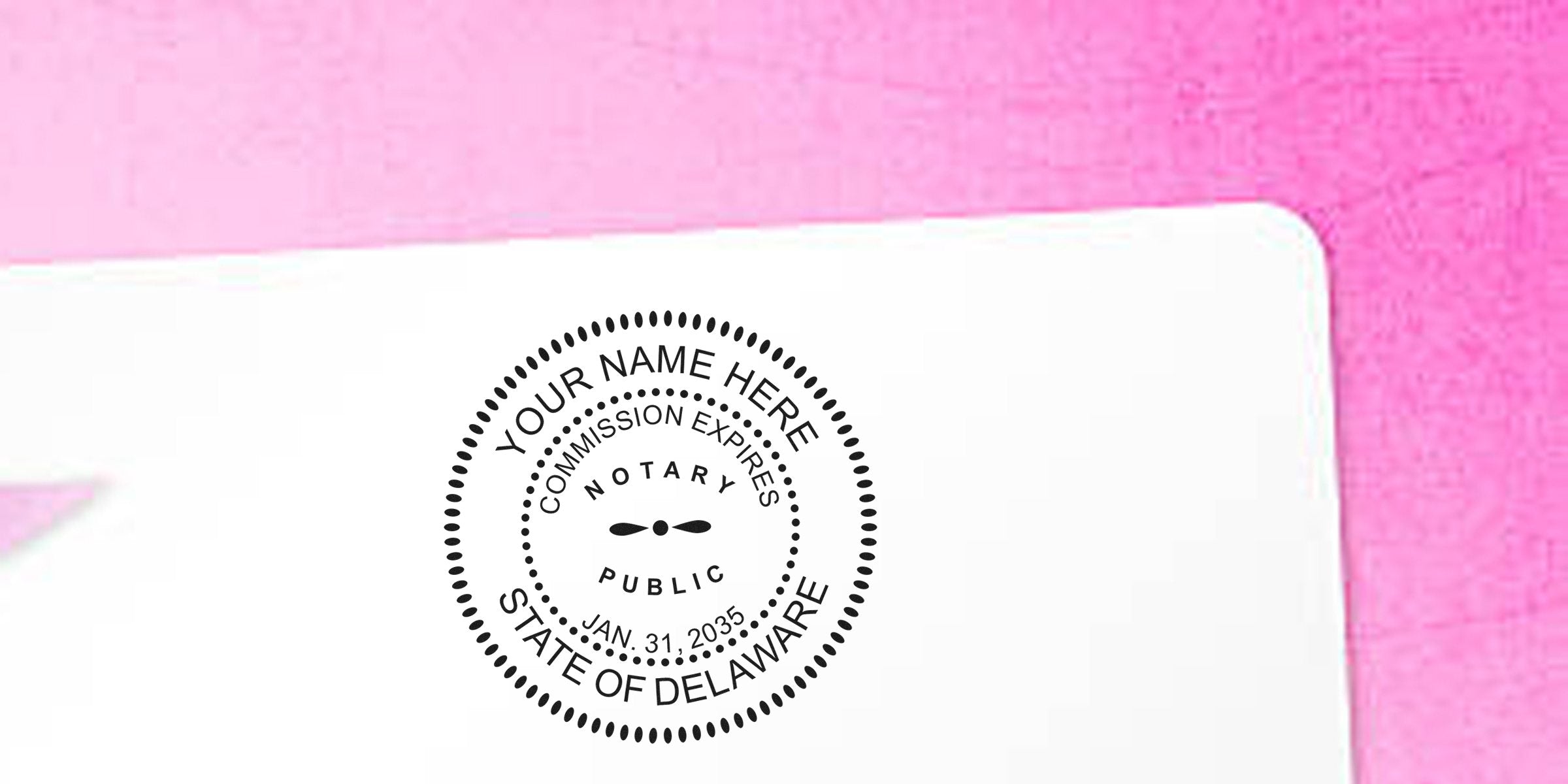 Notary public round stamp mockup reading "YOUR NAME HERE", "Notary Public", "Commission Expires Jan. 31, 2035", "State of Delaware" on white paper with pink background