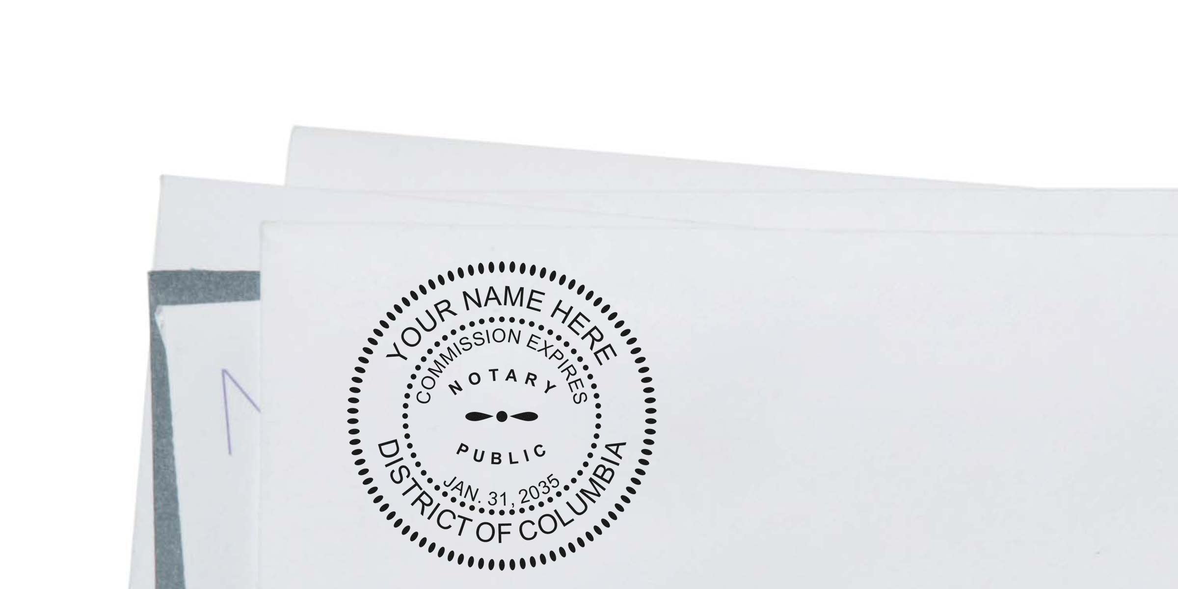Close-up of a black circular Notary Public stamp reading "Your Name Here, District of Columbia" printed on white envelopes, showing commission expiry date and decorative dotted border for legal documents and mailing.
