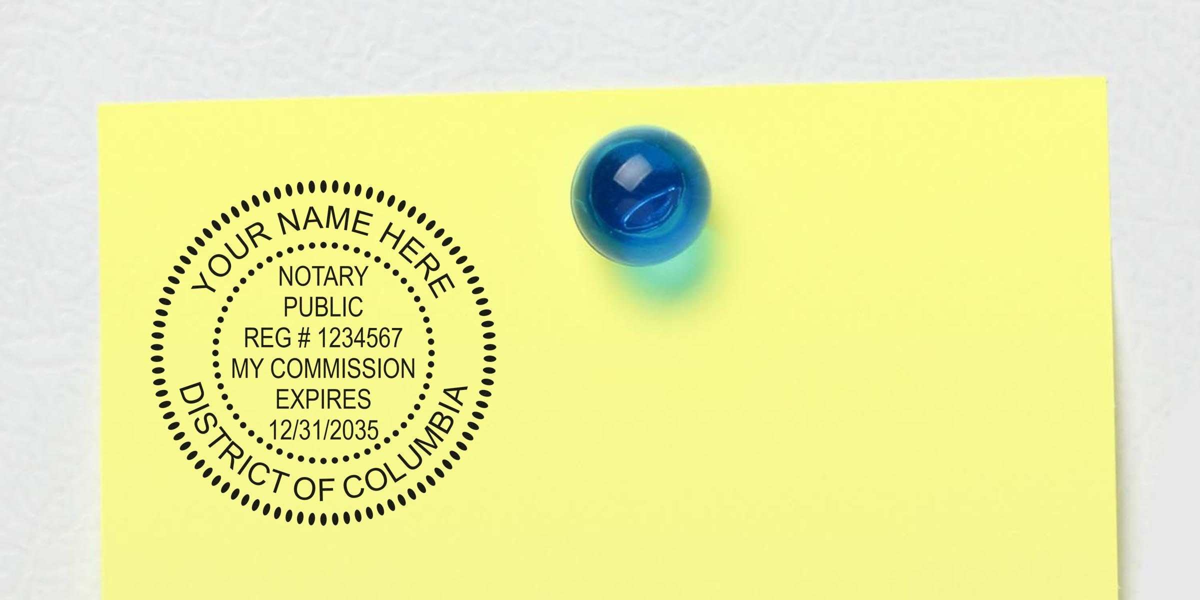Yellow sticky note pinned with a blue glass pushpin displaying a circular notary public seal stamp reading "Notary Public, Reg #1234567, My Commission Expires 12/31/2035, District of Columbia."