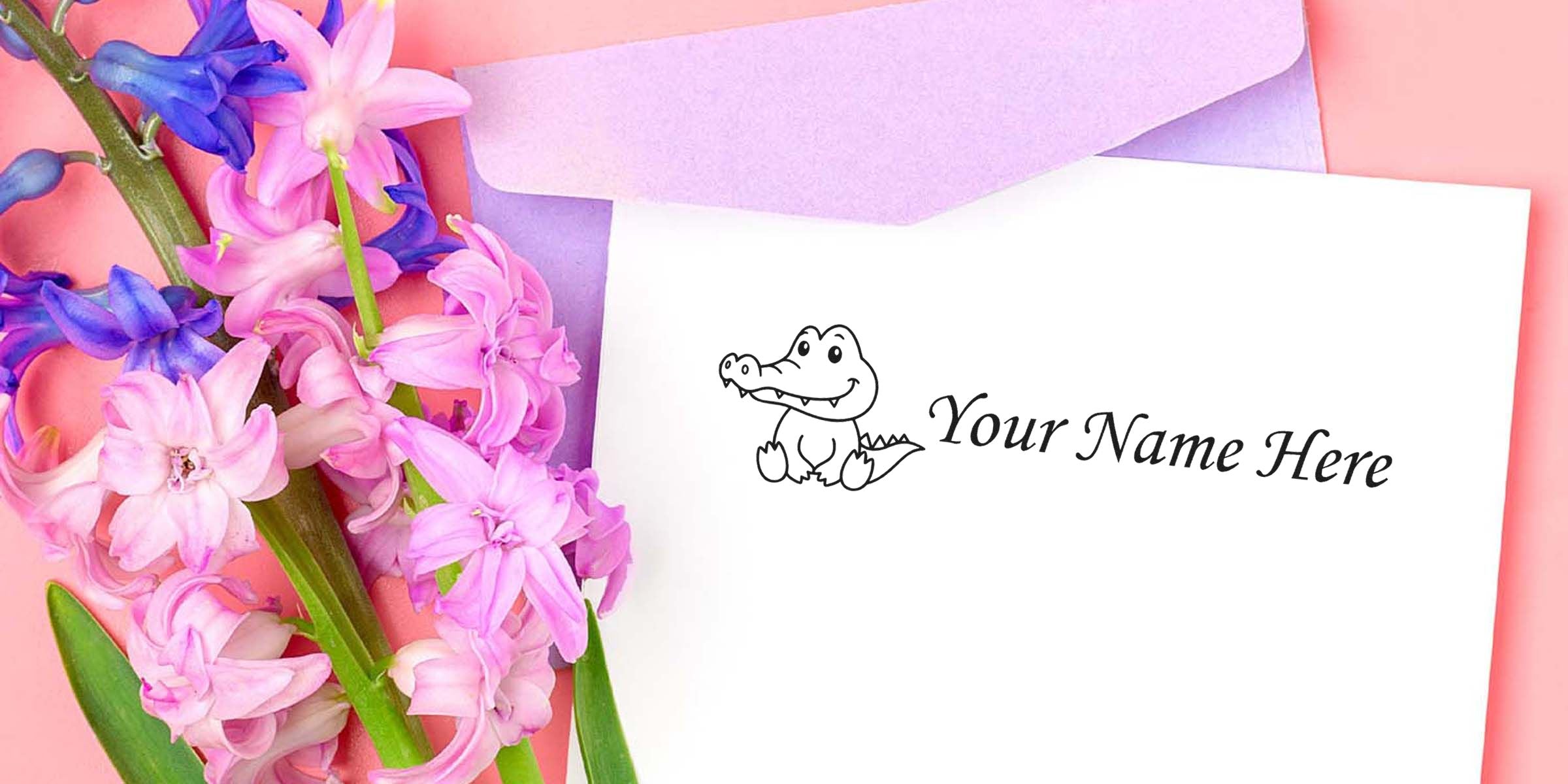 Card with a cute cartoon alligator and the placeholder text “Your Name Here,” beside pink flowers and light purple envelopes.