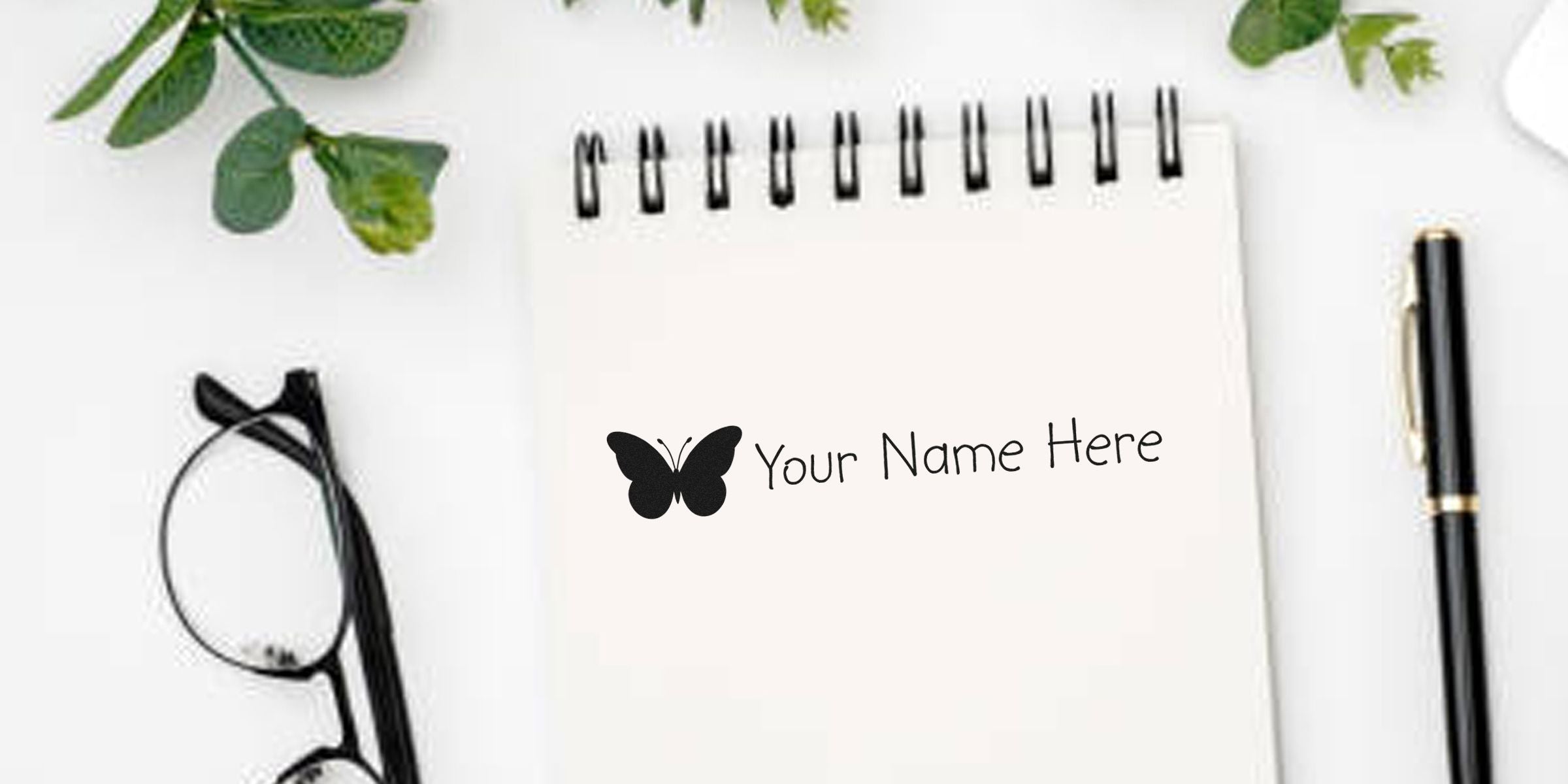 A spiral notebook with a butterfly icon and the words “Your Name Here.”
