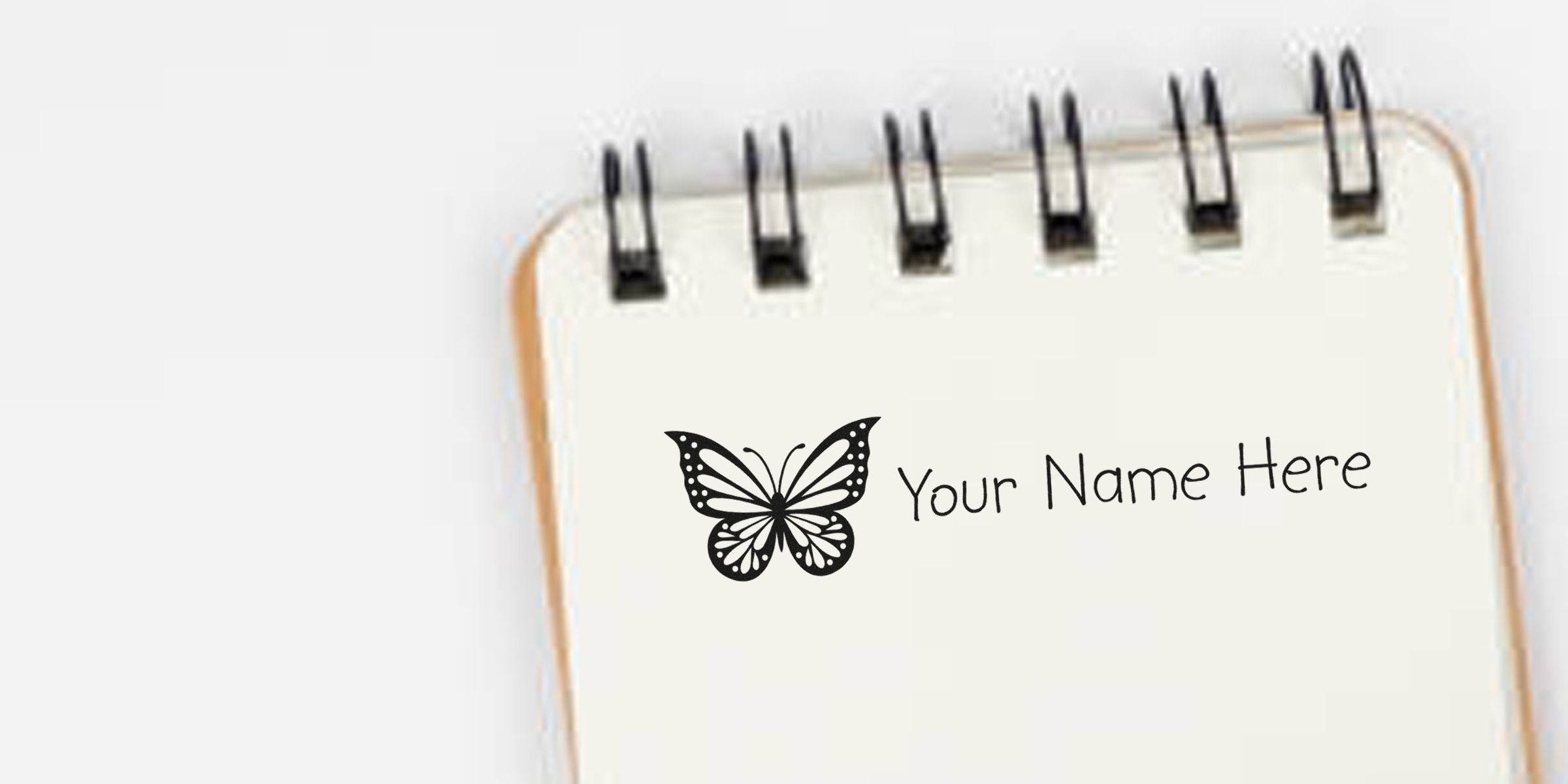 Notebook showing a butterfly graphic with the text “Your Name Here.”