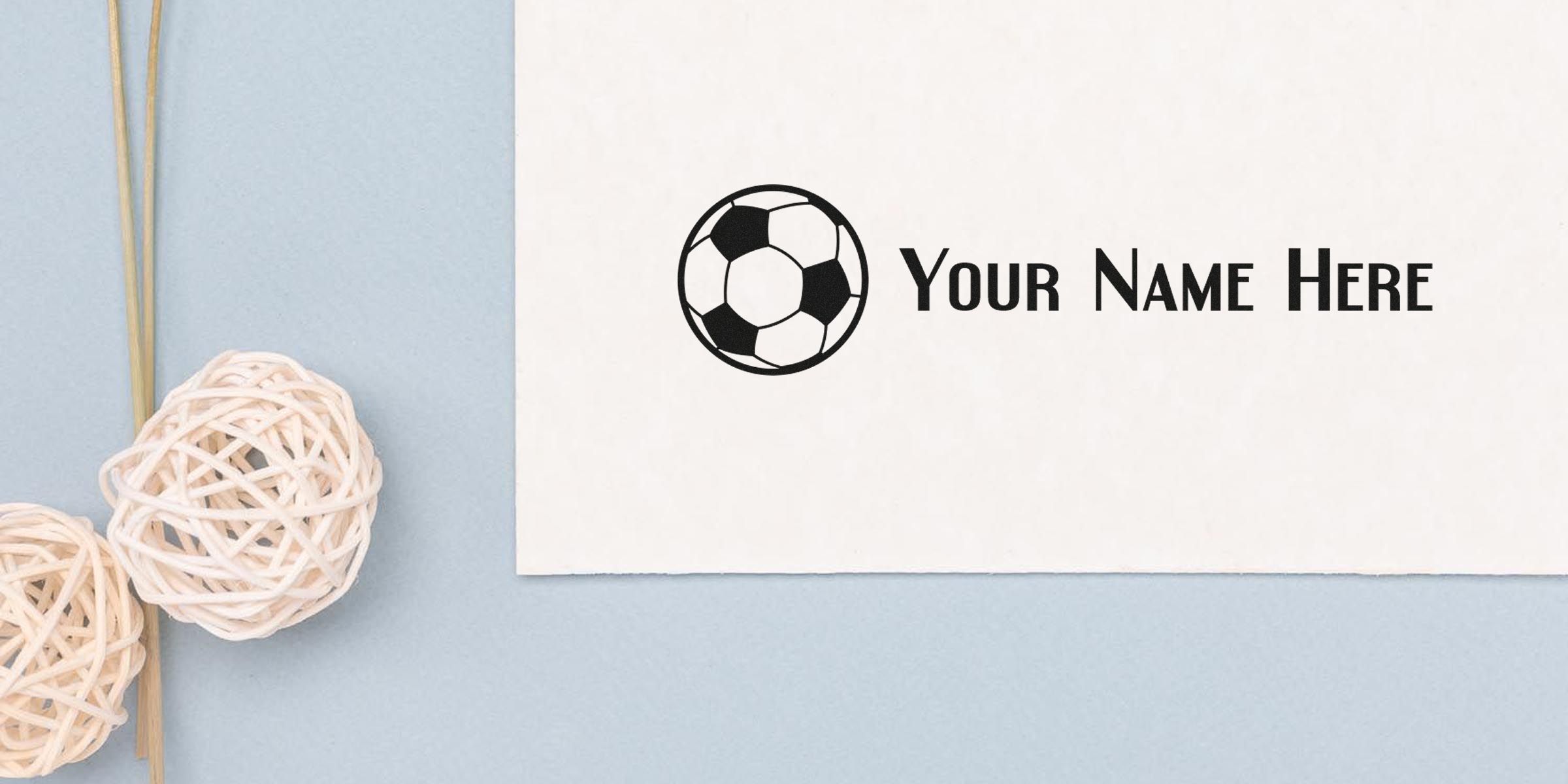 White card with a black soccer ball logo and the text “Your Name Here” on a pale blue background with decorative woven balls.