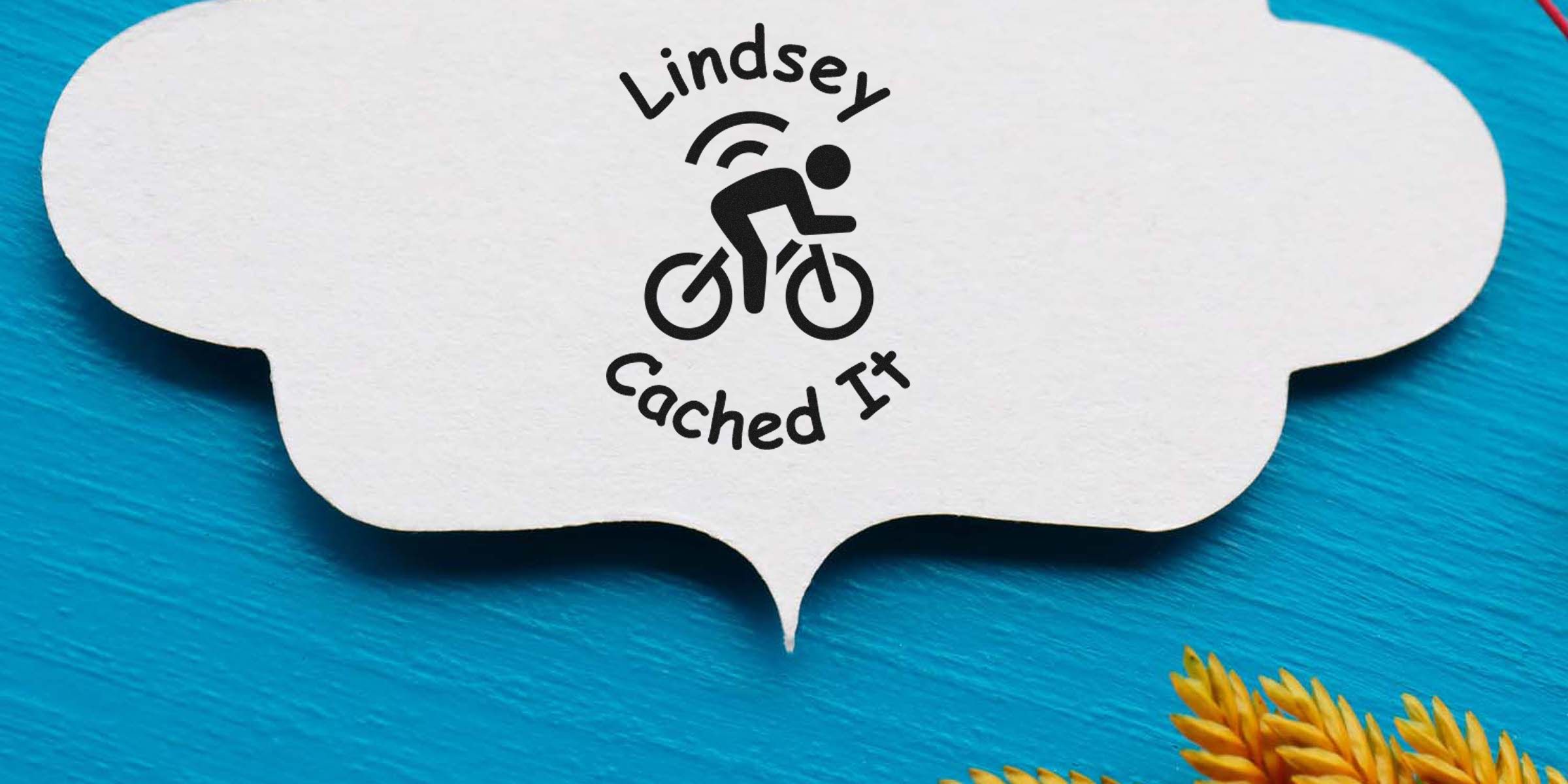 Logo of Lindsey Cached It featuring a cyclist icon inside a white speech-bubble on a blue background.