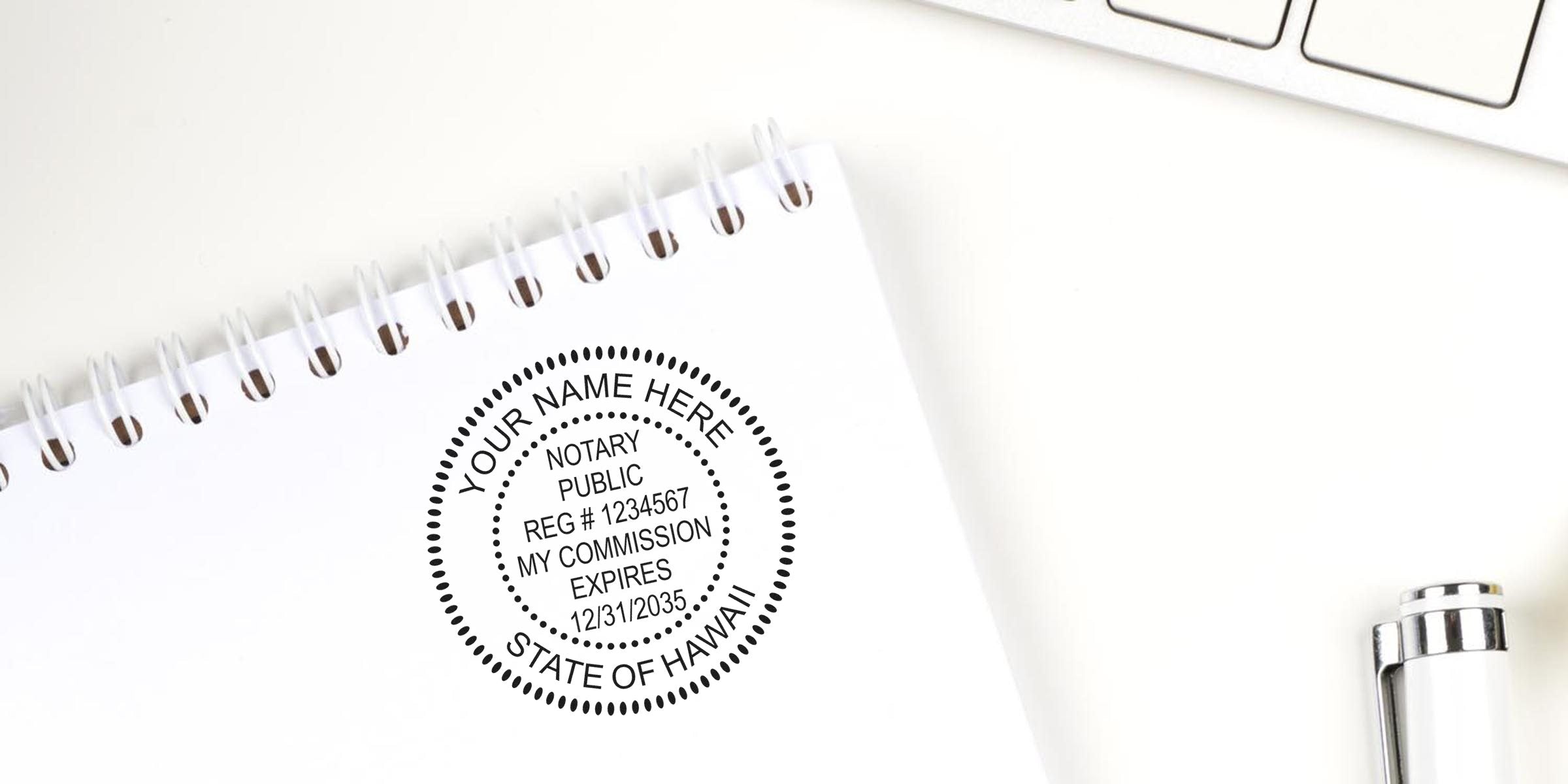 Top-down photo of a spiral notebook stamped with a black circular notary public seal reading "Notary Public" and "State of Hawaii," with a white pen clip and laptop keyboard on a white desk — office notary seal concept.