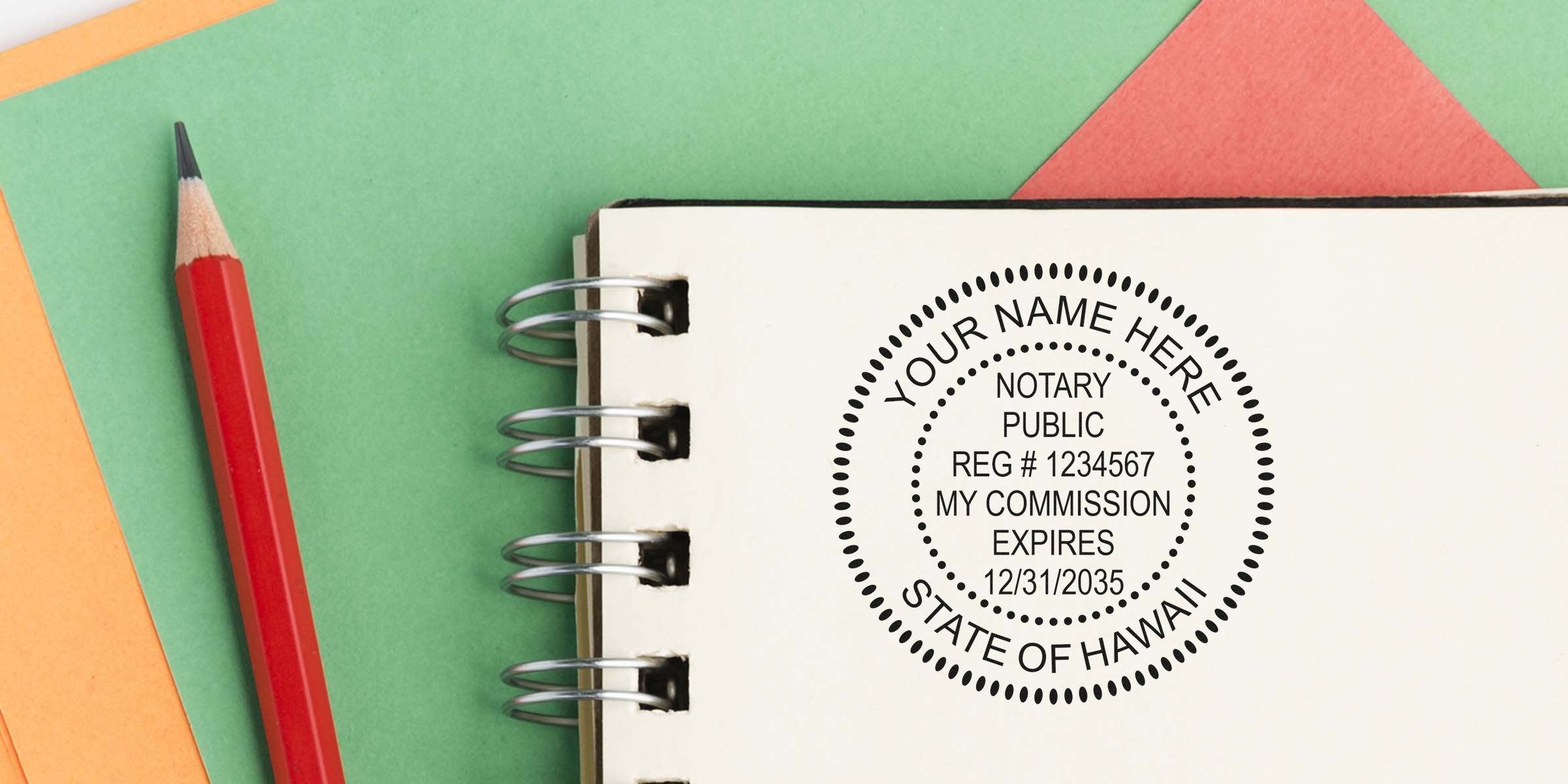 Notary public rubber-stamp imprint on a spiral notebook page reading "Your Name Here, State of Hawaii" with registration number and commission expiry, shown beside a red pencil on green and orange paper — notary/legal document concept.