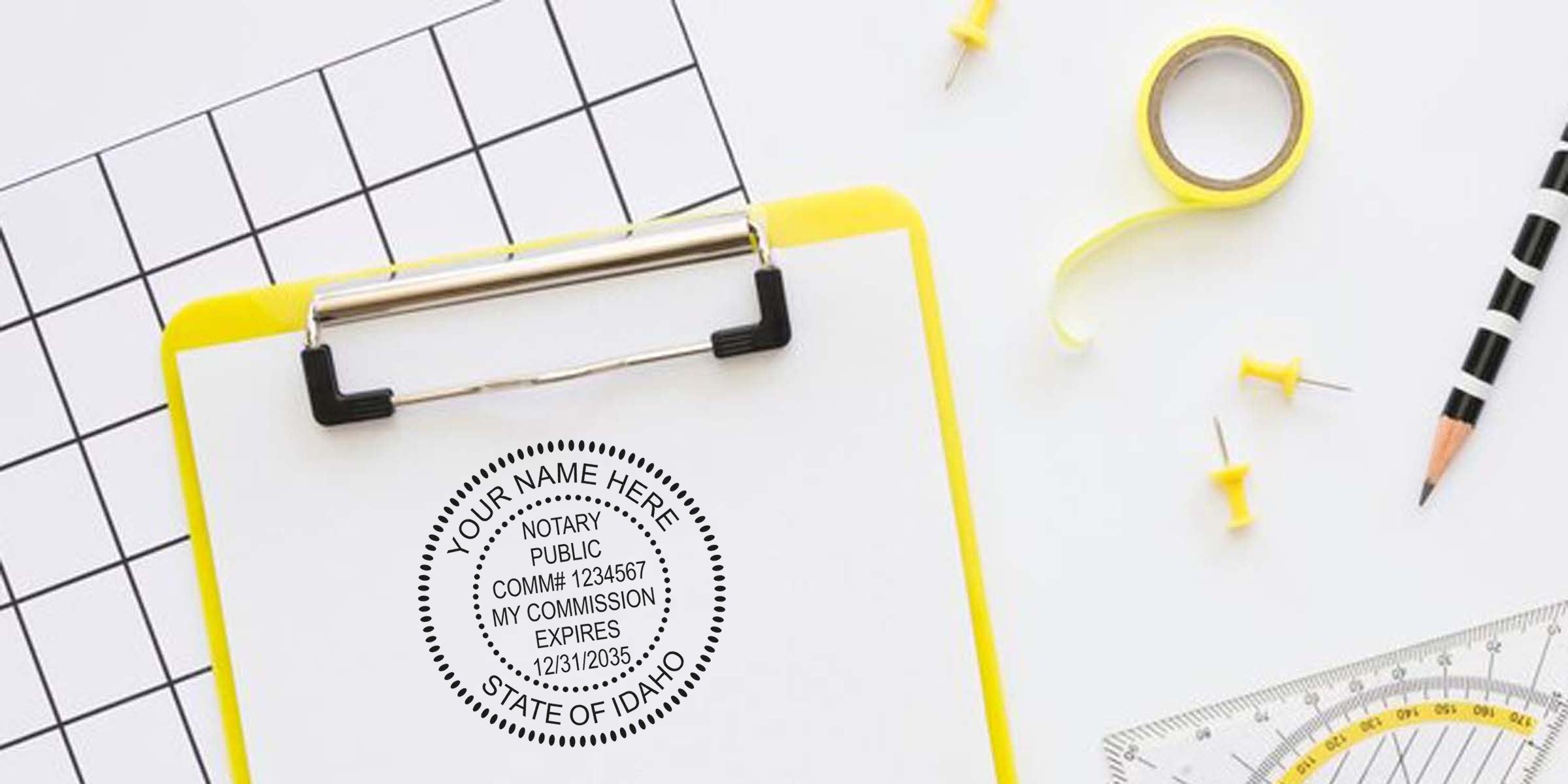 Overhead flatlay of yellow clipboard holding paper stamped with a notary public seal, black-and-white grid paper, yellow push pins, washi tape, striped pencil and clear protractor — office stationery and notary seal concept