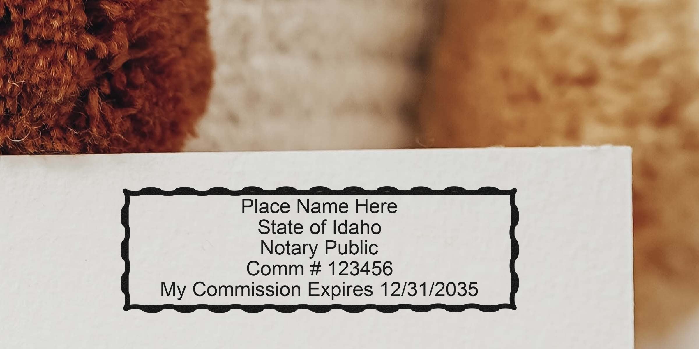 Idaho notary public stamp on paper with decorative scalloped border showing placeholder name, commission number 123456 and commission expiration date 12/31/2035