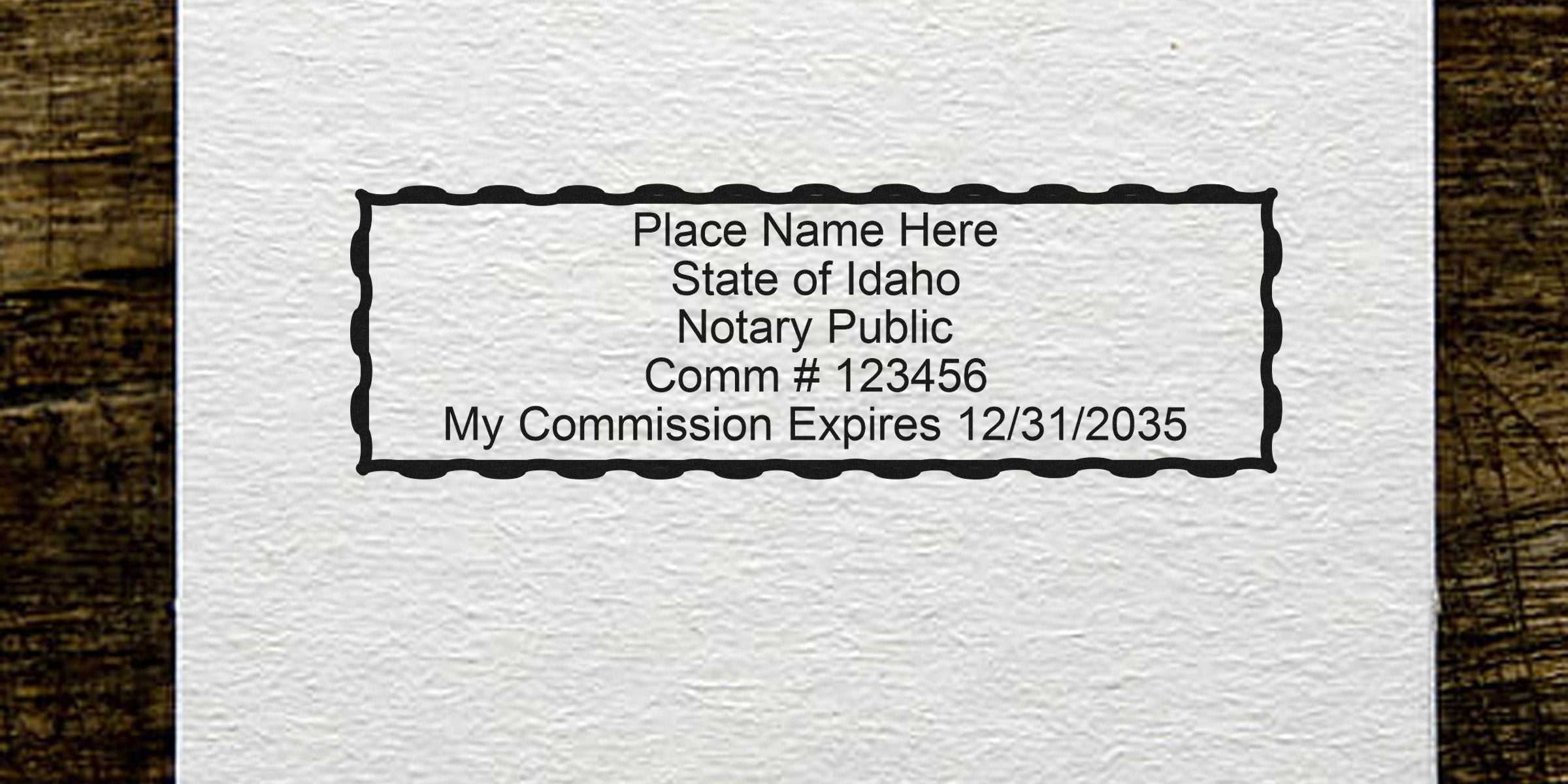 Notary stamp template on textured paper: "Place Name Here, State of Idaho Notary Public, Comm #123456, My Commission Expires 12/31/2035" inside decorative rectangular border with wood edges.