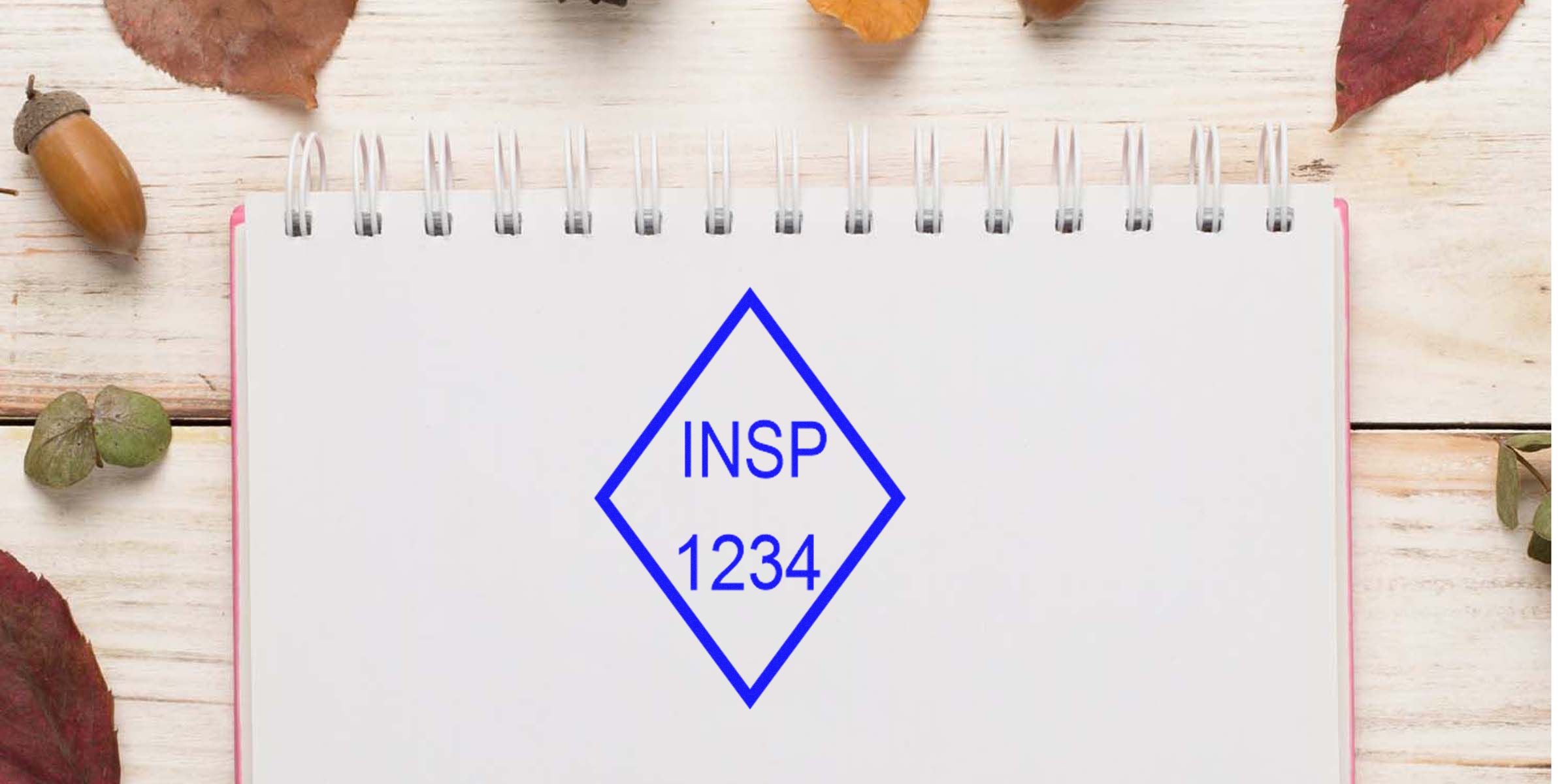 Notebook with a blue diamond emblem reading INSP 1234 on a wooden table.