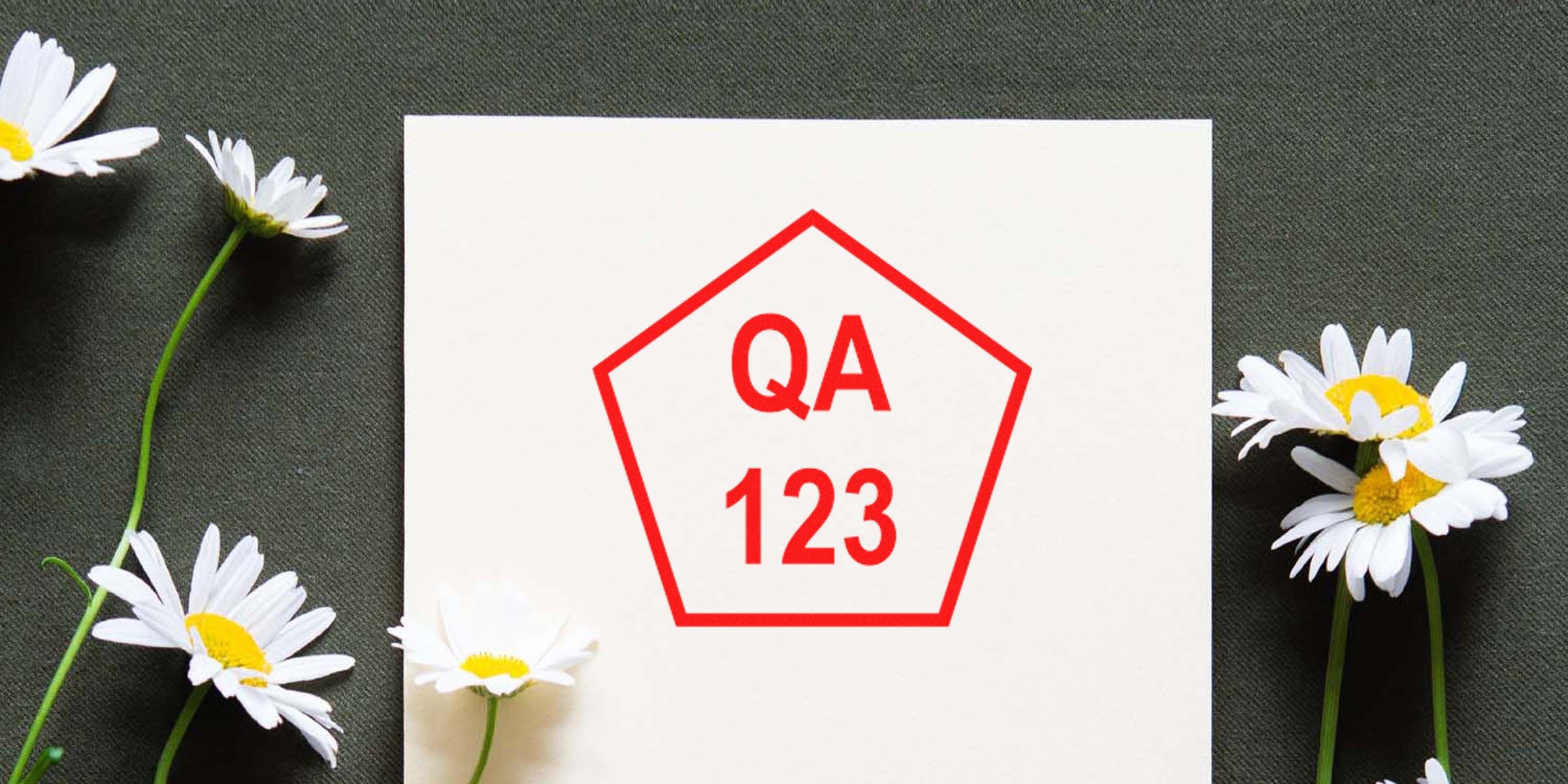 Card with a red pentagon outline containing the text “QA 123,” set on a white square with white daisies around it.