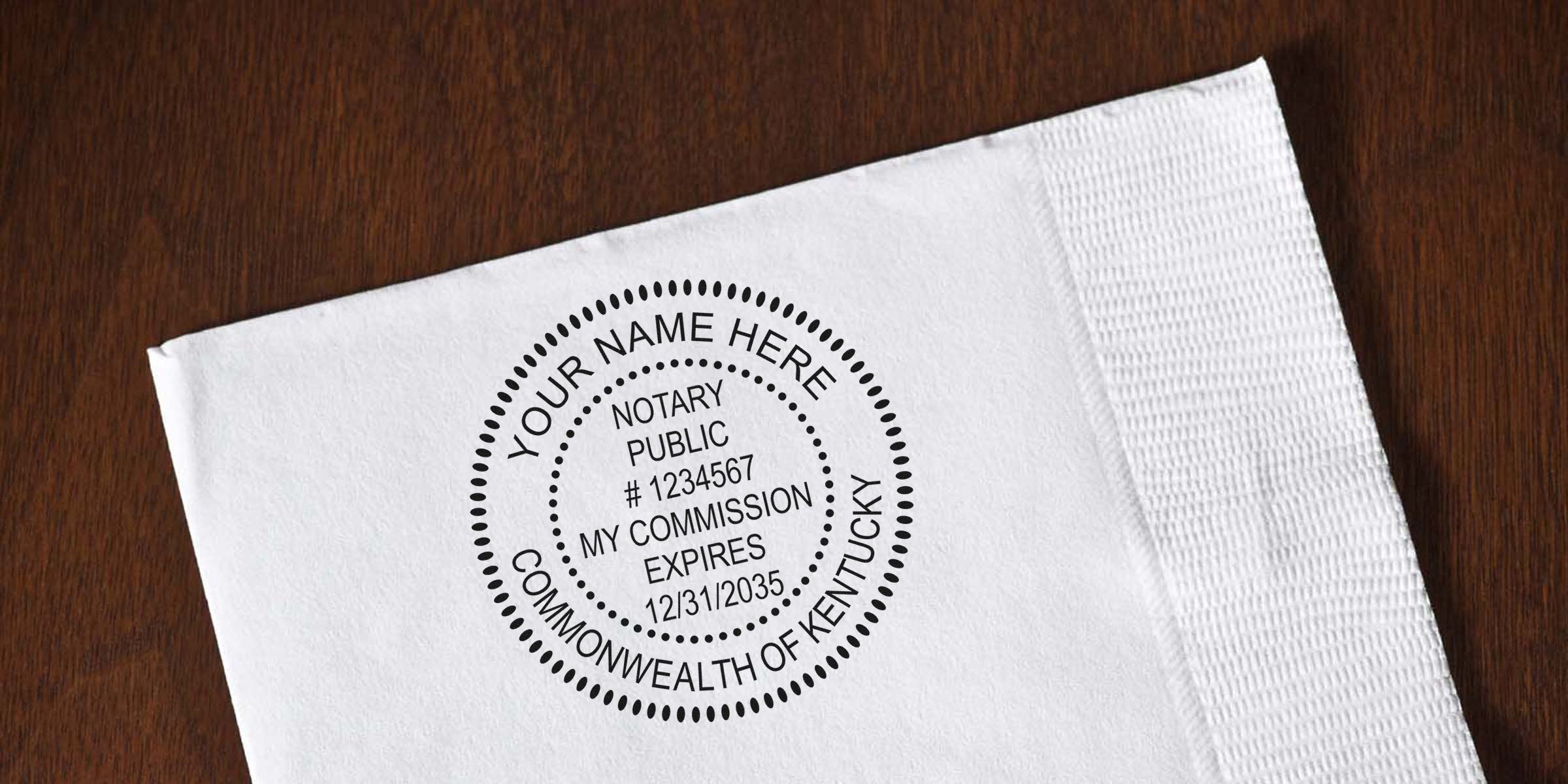 Close-up of a circular notary public stamp mockup on a white napkin/paper over a wooden table, customizable "Your Name Here," Kentucky notary seal with commission expiration date.