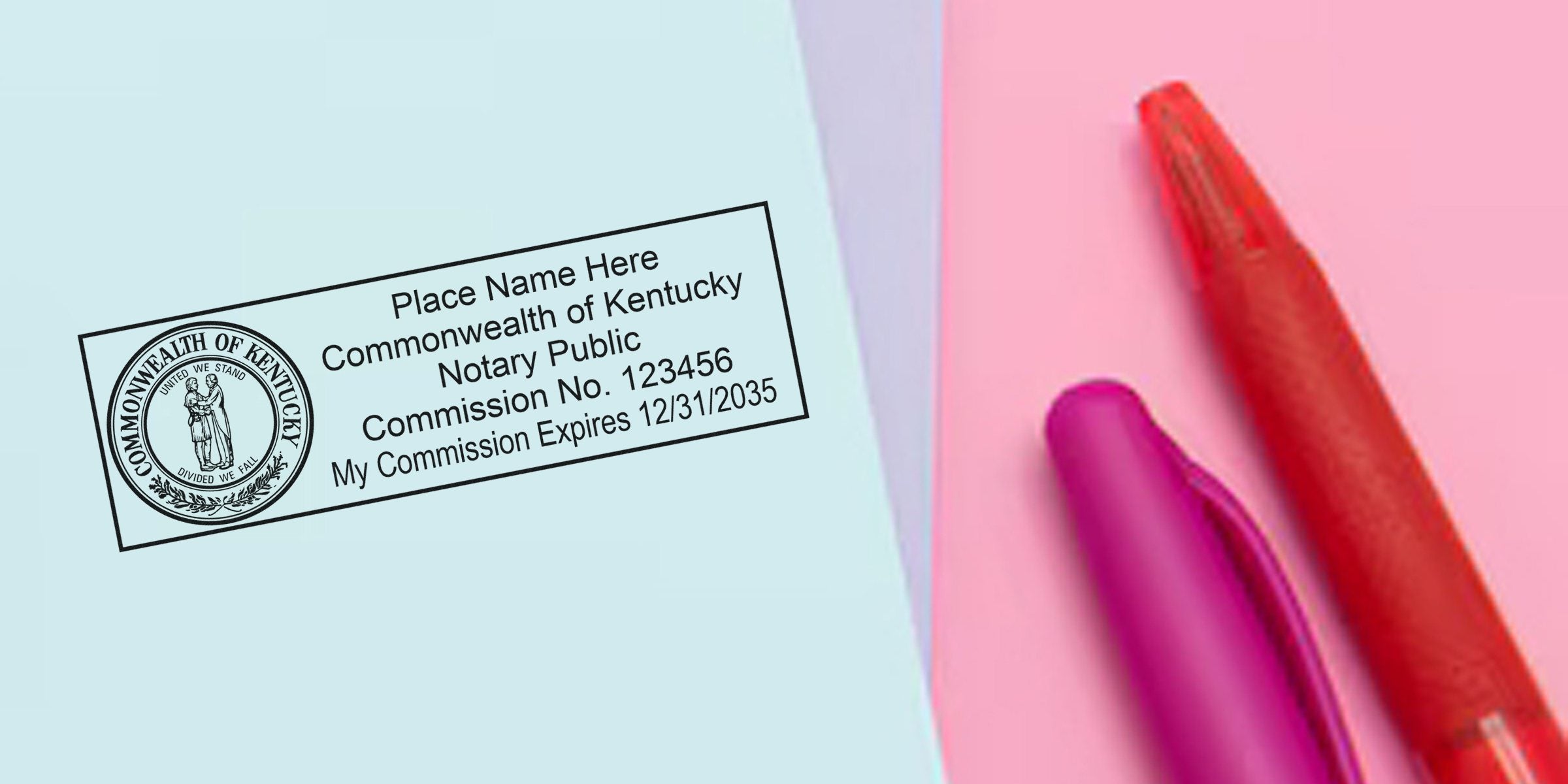 Kentucky notary public rubber stamp impression with Commonwealth seal, sample commission number and expiration date on pastel paper beside red and purple pens