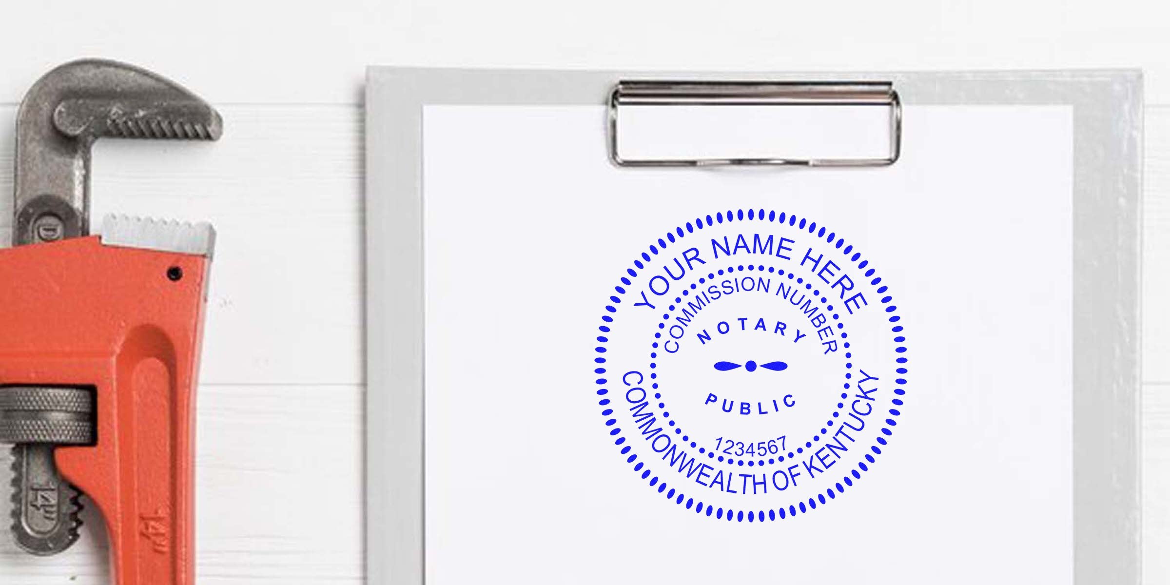 Blue circular notary stamp mockup reading "COMMONWEALTH OF KENTUCKY" on white paper clipped to a metal clipboard, with a red pipe wrench partially visible at left — notary seal design, commission number placeholder.