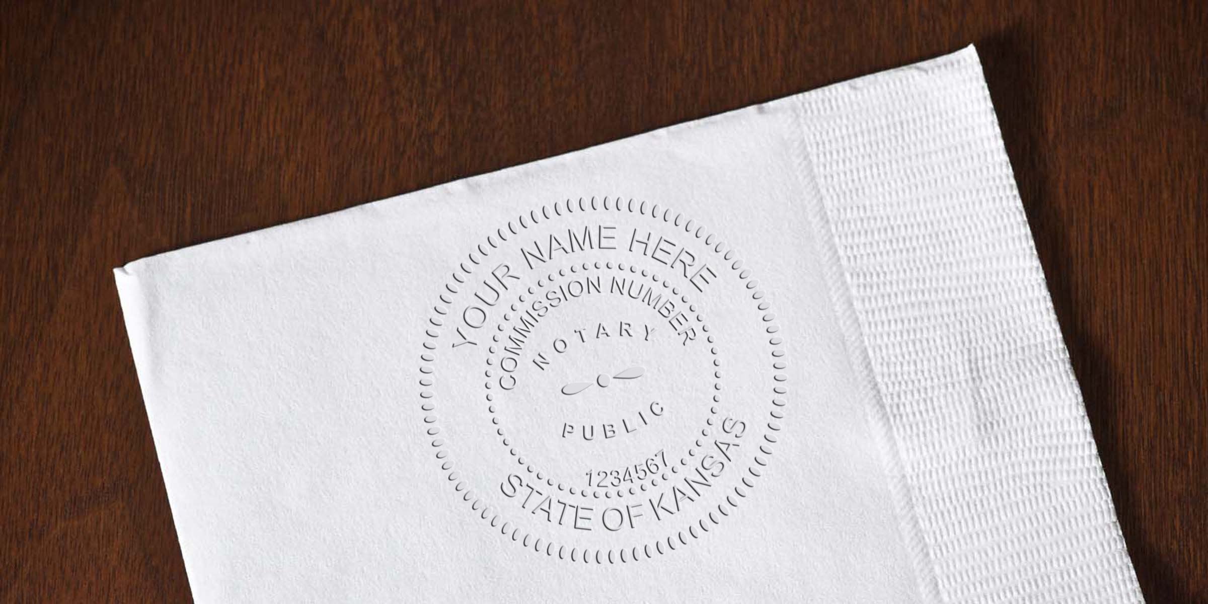 Embossed Kansas notary public seal on white paper over wood surface, customizable "Your Name Here" text and sample commission number.