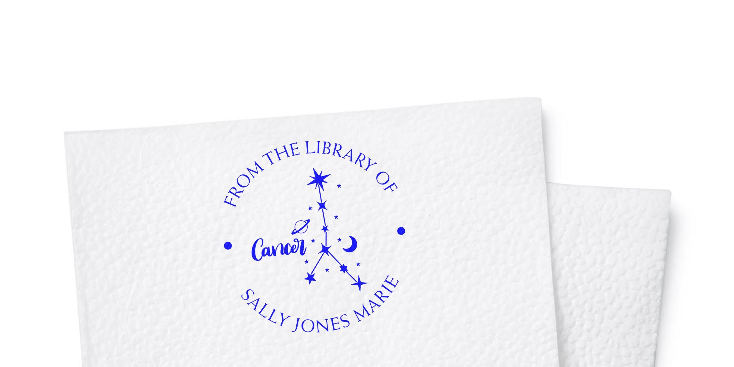 Blue circular stamp reading “FROM THE LIBRARY OF” around the edge, with “Cancer” in script and the name “SALLY JONES MARIE” below, plus a star/constellation design.
