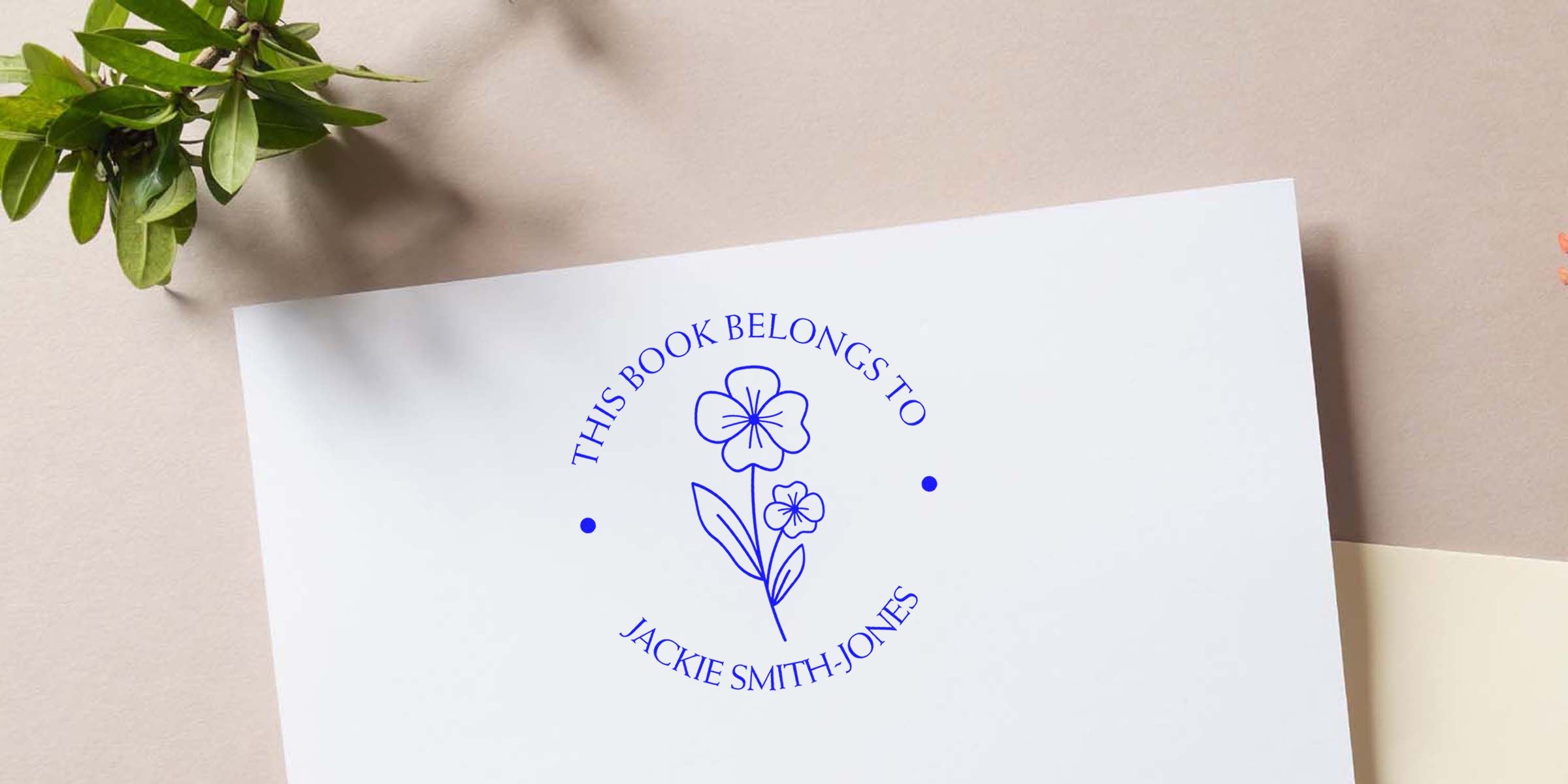 Blue circular stamp reading "THIS BOOK BELONGS TO JACKIE SMITH-JONES" with a floral illustration in the center.