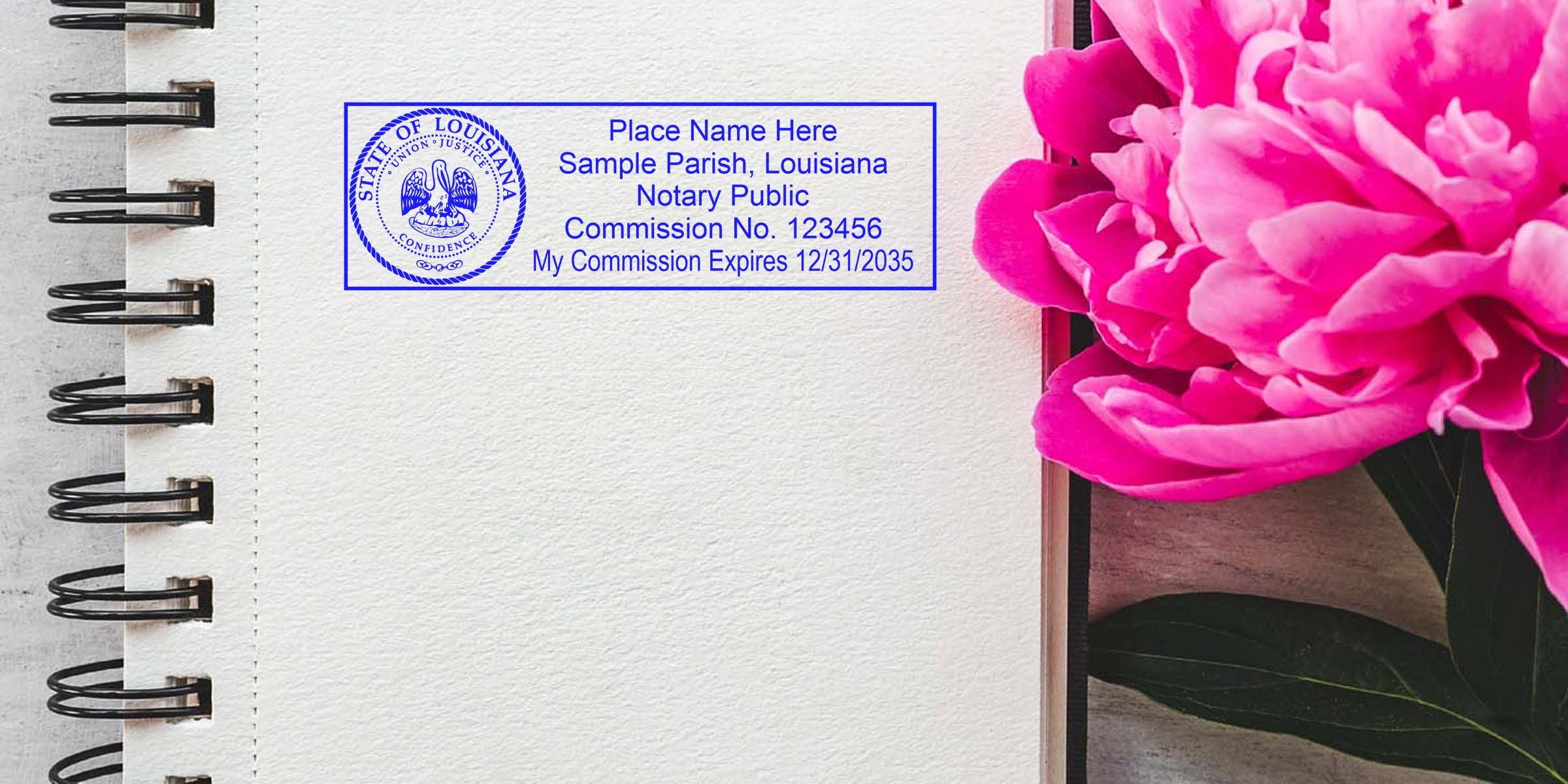 Open spiral-bound notebook with blank textured paper, blue Louisiana notary public stamp and commission details at top left, bright pink peony flower peeking from the right edge.