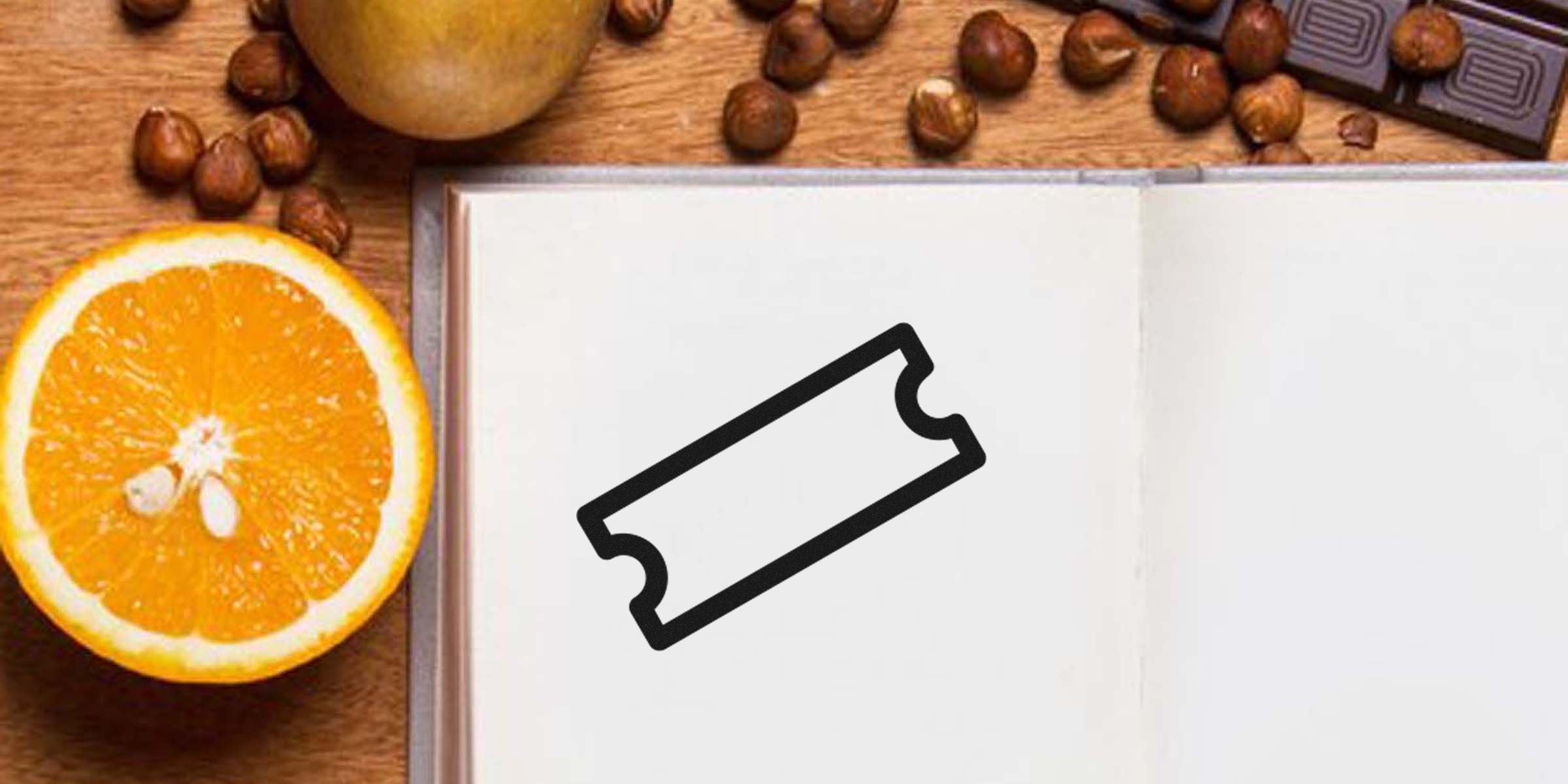 Open notebook with a stylized ticket icon on a blank page, surrounded by an orange slice, nuts, and chocolate on a wooden surface.