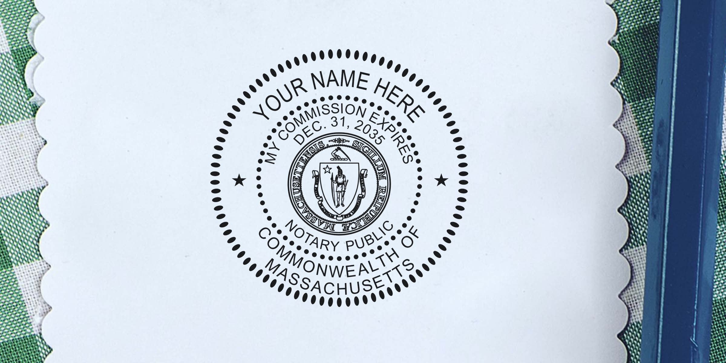 Black circular Massachusetts notary public seal stamp on white scalloped paper, centered state coat of arms and customizable "Your Name Here" text, surrounded by dotted border, green checkered fabric and blue book edge background.