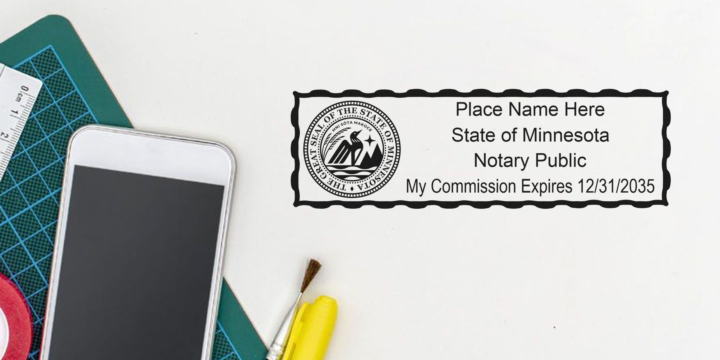 Minnesota notary public stamp sample with state seal, placeholder name and commission expires 12/31/2035 on white desk beside smartphone, cutting mat, paintbrush and yellow highlighter