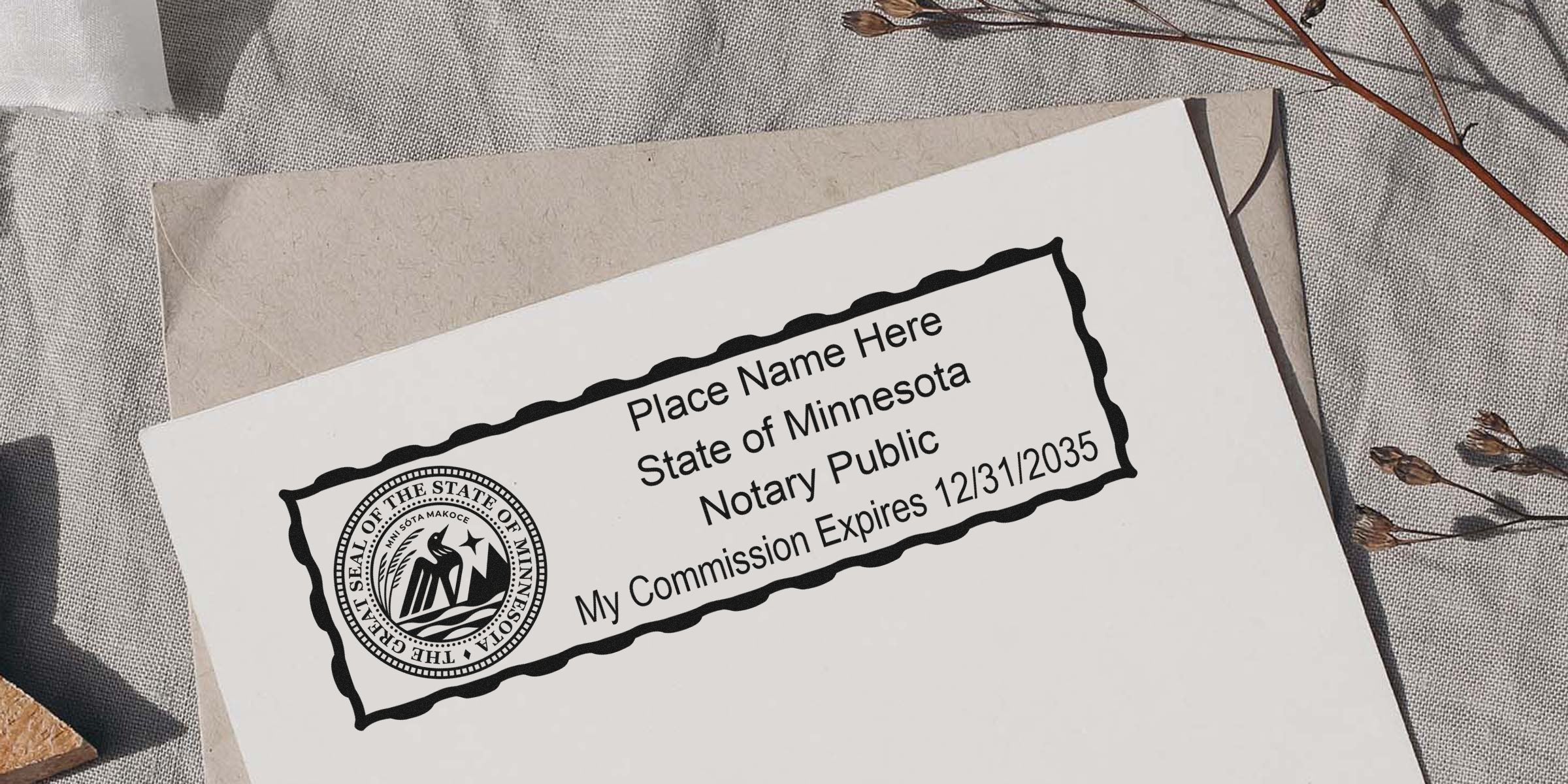 Notary public stamp template on paper featuring the Minnesota state seal, placeholder name, commission expires 12/31/2035, wavy decorative border, placed on a neutral linen surface with an envelope and dried flowers nearby