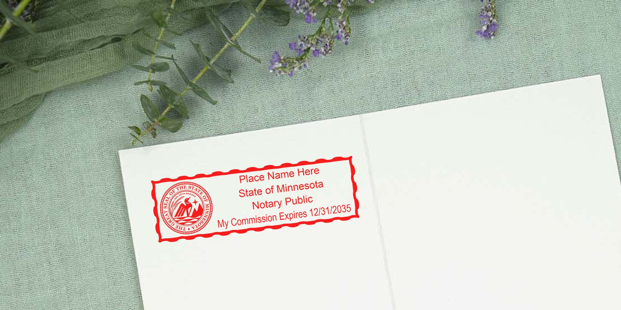 Red Minnesota notary public stamp on white card showing state seal, placeholder name and commission expiration 12/31/2035, green fabric and purple sprigs background