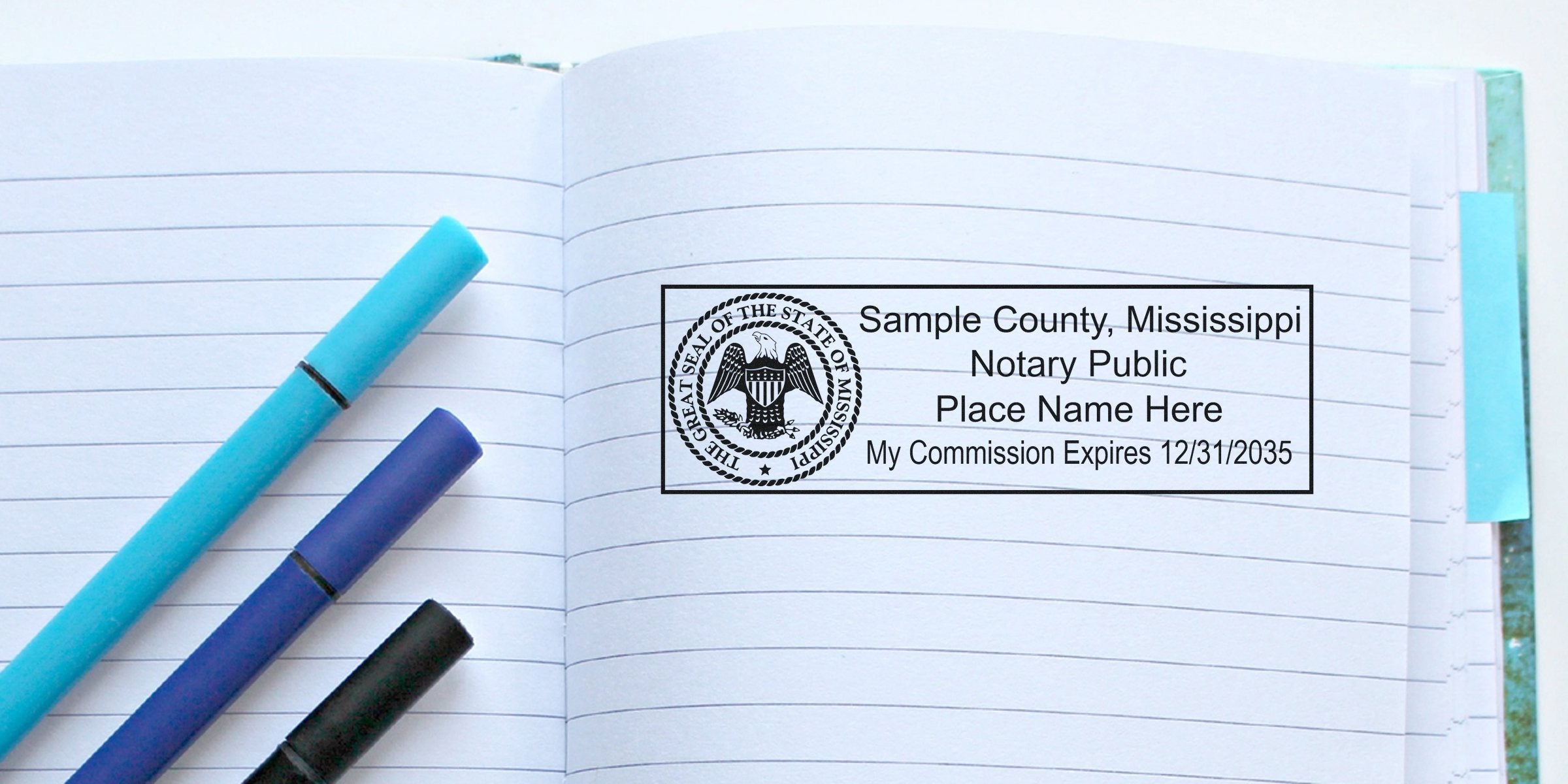 Open lined notebook spread with three pens (light blue, navy, black) resting on left page and a rectangular "Sample County, Mississippi Notary Public" stamp imprint with state seal and commission expiration date on right page.