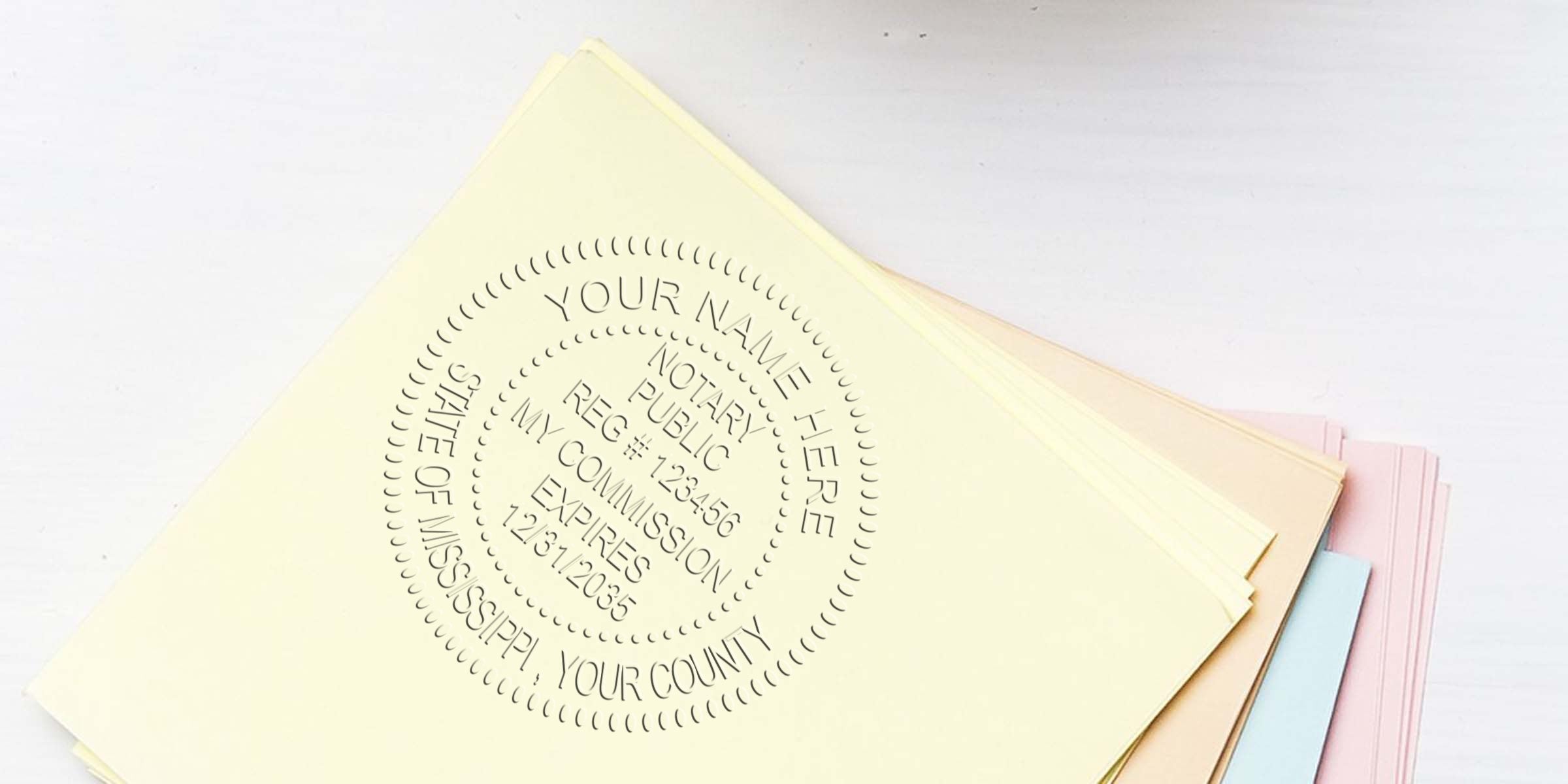 Embossed notary seal impression on pale yellow paper atop a stack of pastel stationery (pink, blue, cream) on a white wooden desk — close-up of notary stamp detail