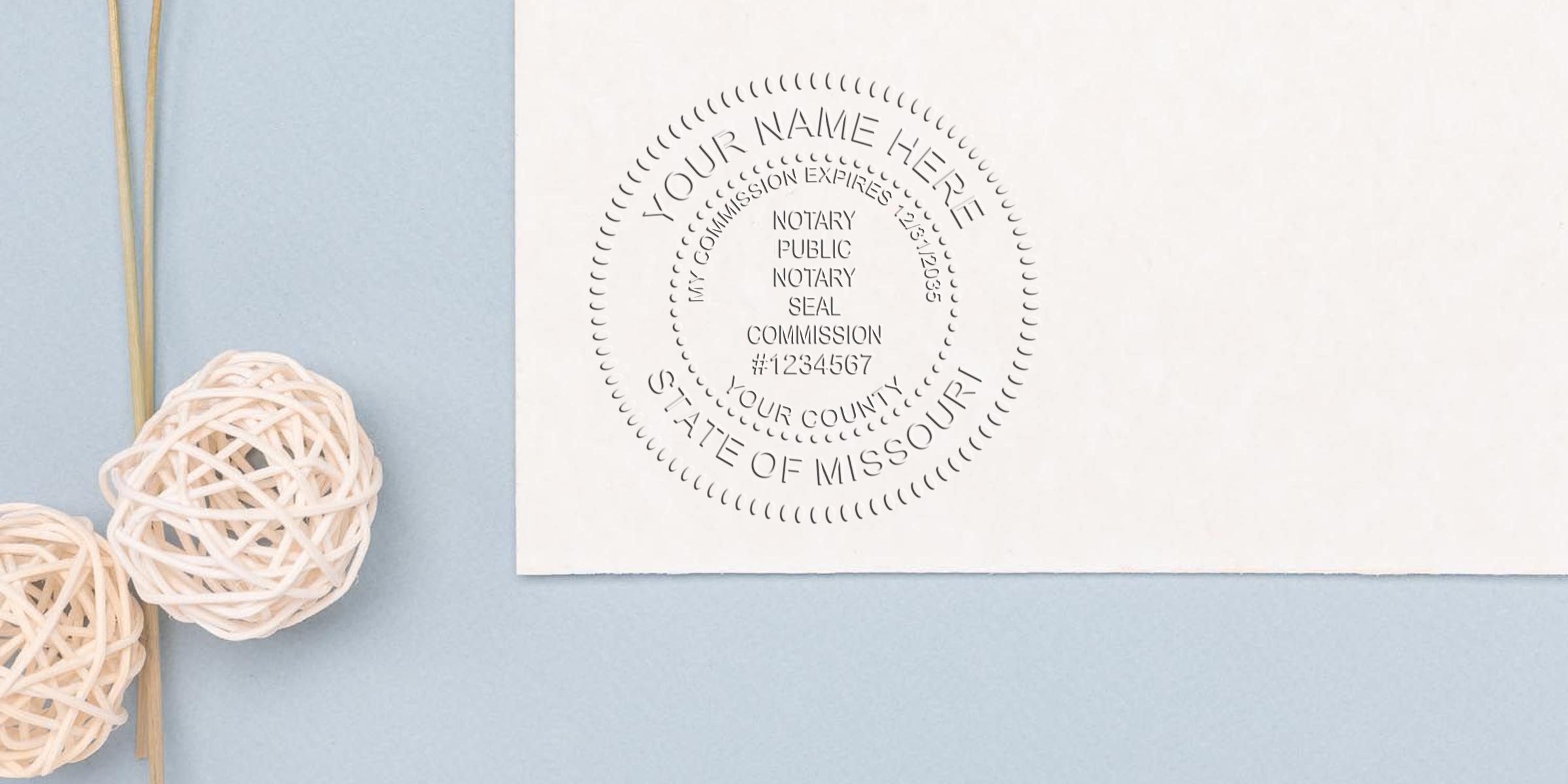 Embossed notary public seal on white paper reading "State of Missouri," "Notary Public" and commission number, photographed on a pale blue background with decorative wicker balls — professional notary seal document image
