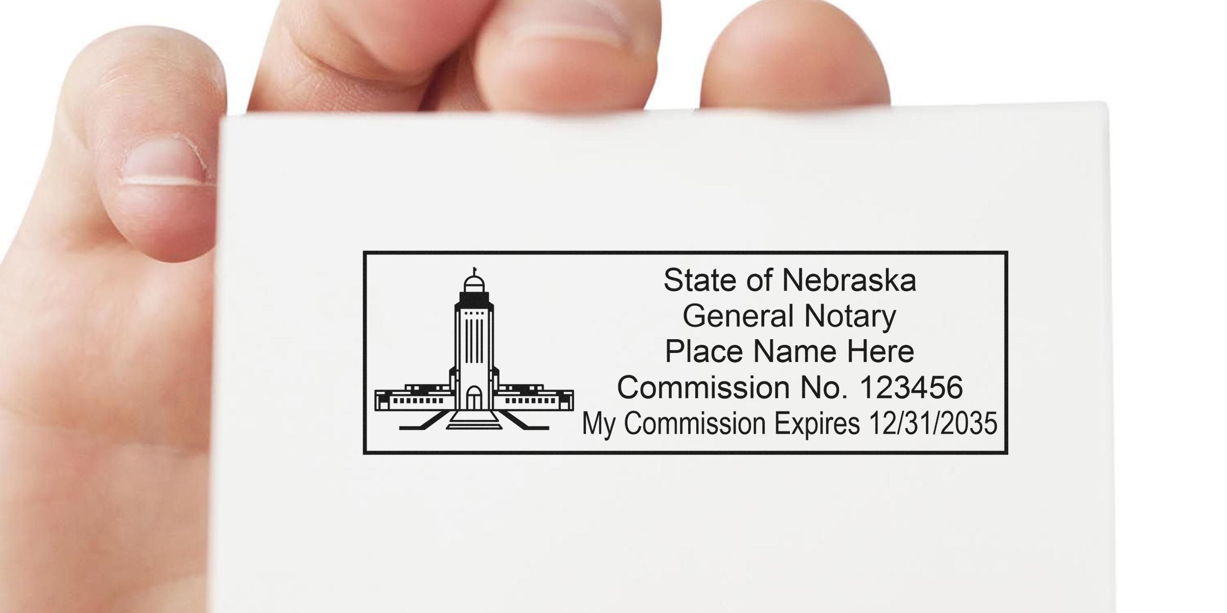 Hand holding white card with State of Nebraska general notary stamp showing capitol illustration, placeholder name, Commission No. 123456 and expiration 12/31/2035