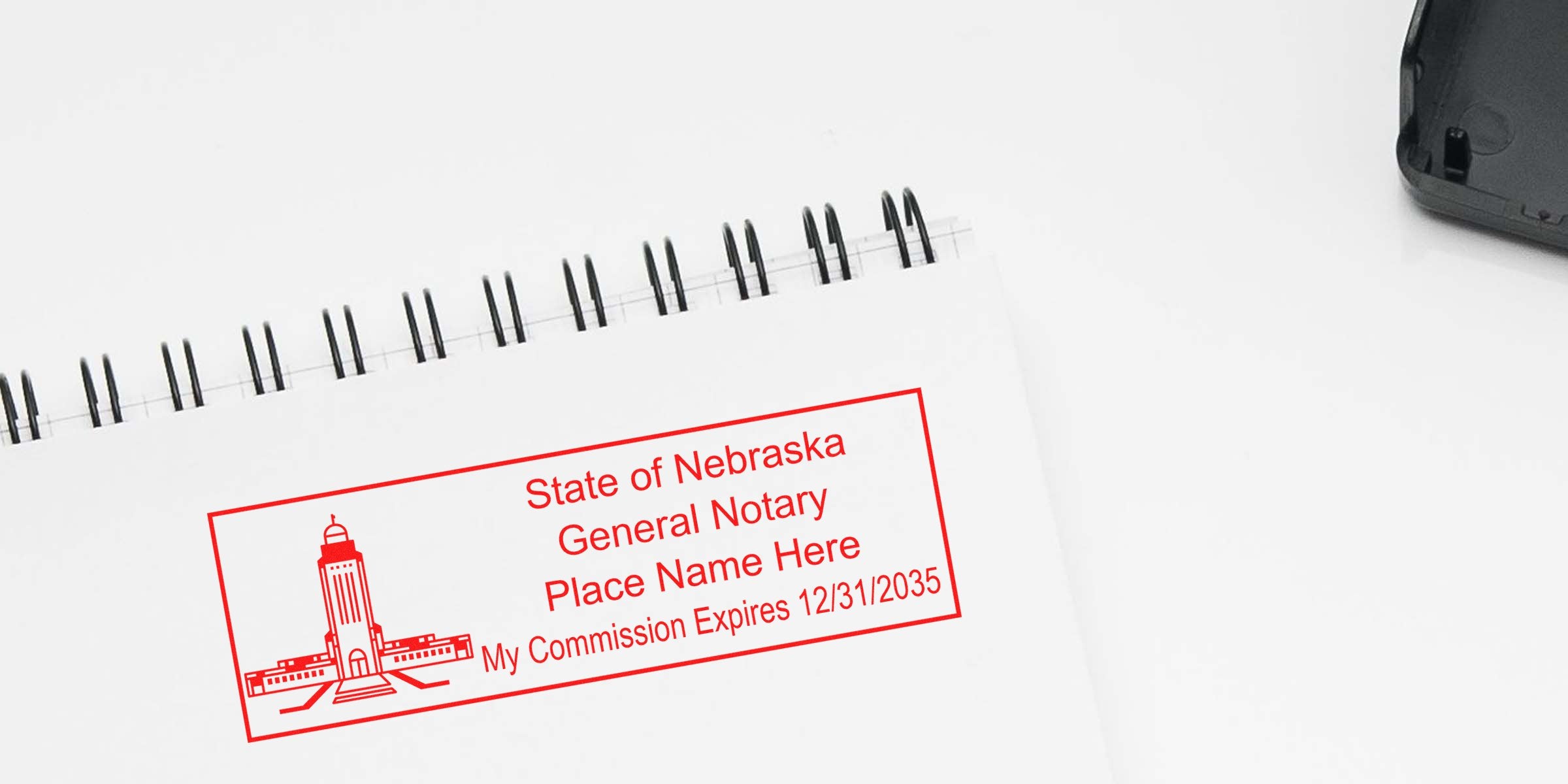 Red Nebraska notary stamp impression in red ink on spiral notebook showing state seal, "State of Nebraska General Notary," name placeholder and commission expiration date.