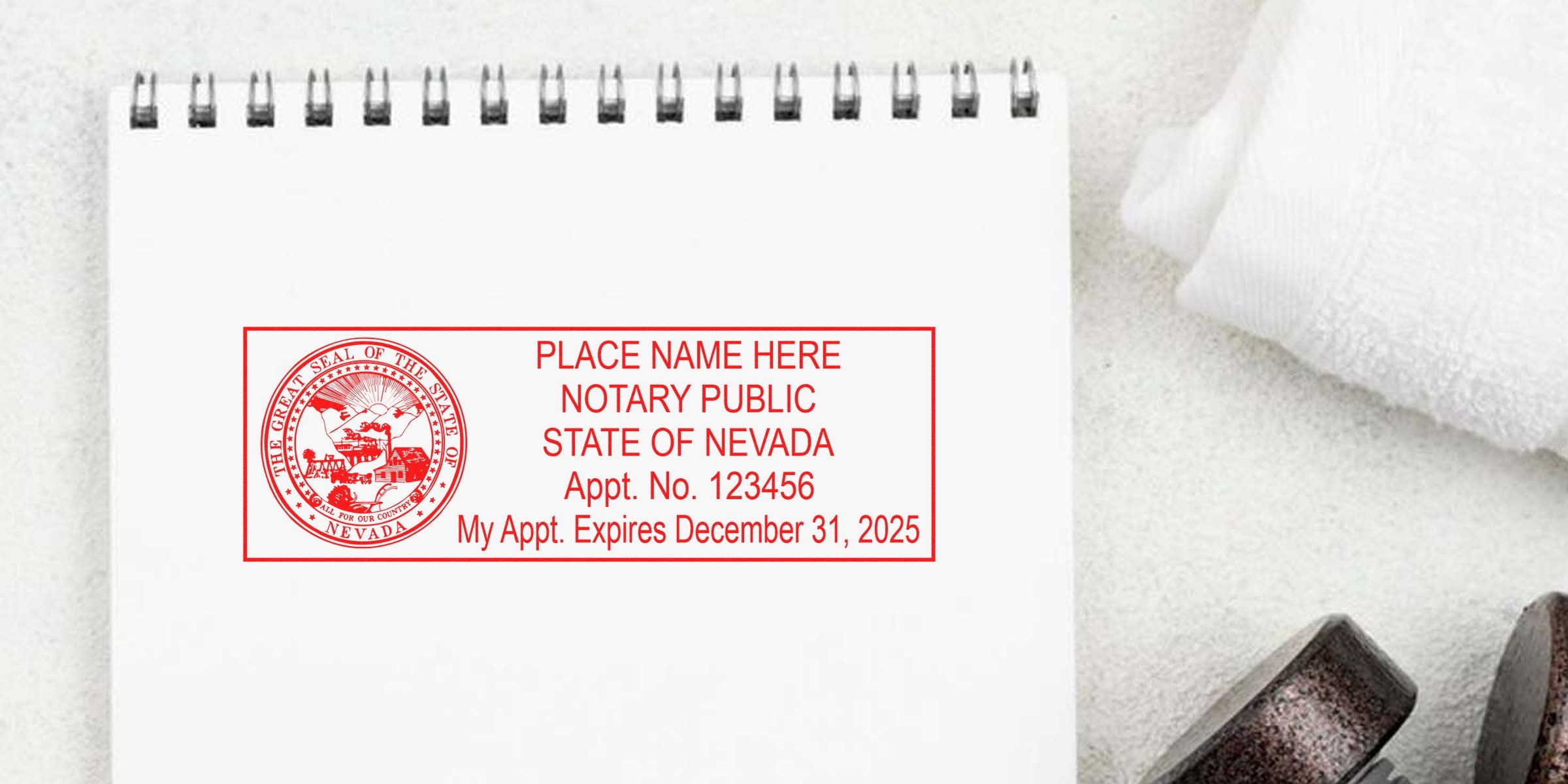 Red ink Nevada notary public stamp on spiral notebook showing state seal, placeholder name, appointment number and expiration date—notary stamp image for Nevada notary services and documents.