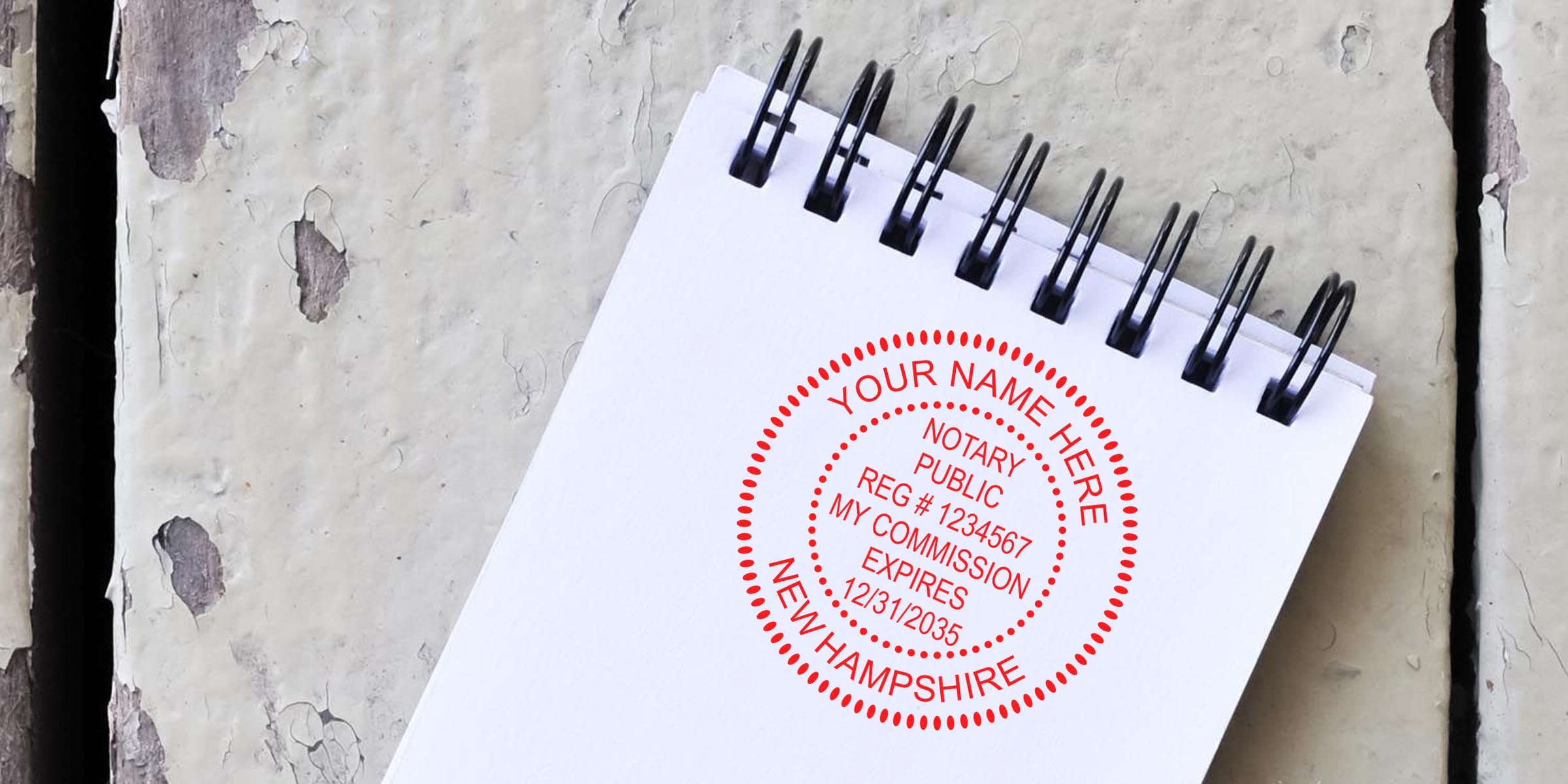 Red circular notary public stamp on a spiral notepad reading "Your Name Here, Notary Public, Reg #1234567, Expires 12/31/2035, New Hampshire" on blank white paper over distressed painted wood background